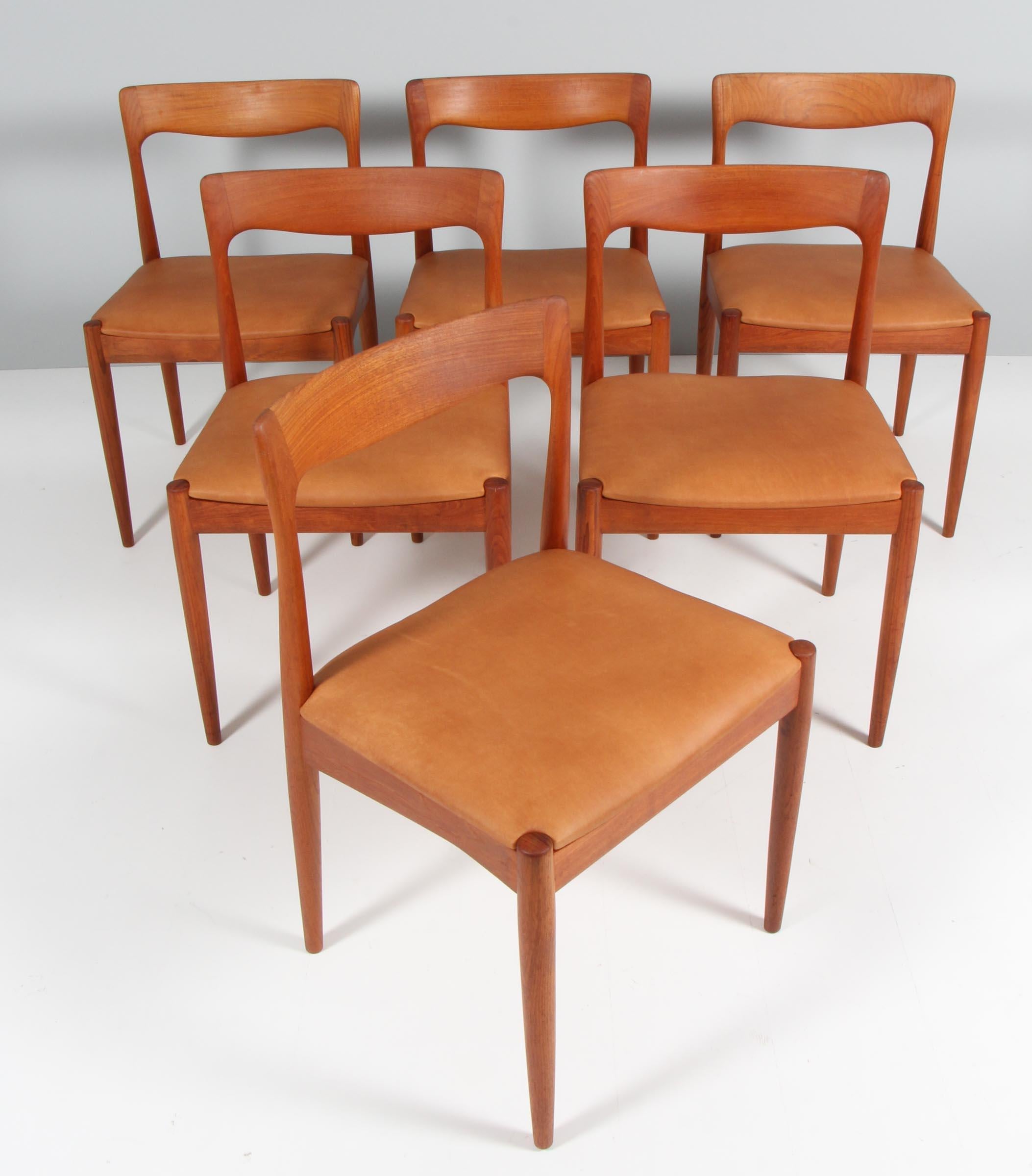 Set of six Arne Vodder dining chairs in solid teak.

New upholstered seats with tan aniline leather.

Made by Vamo.