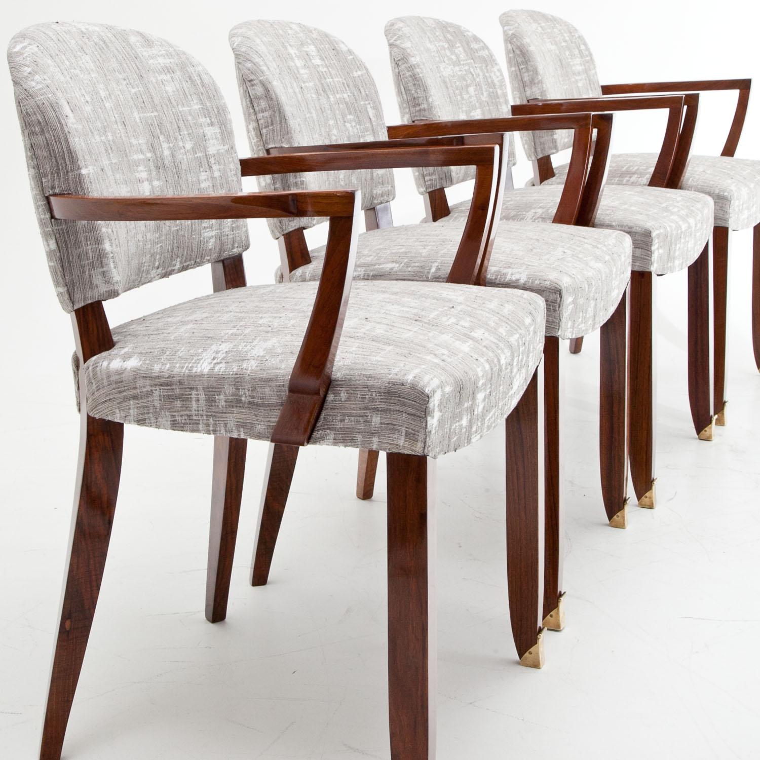 Six Art Deco armchairs by Jules Leleu on minimally curved front legs with brass sabots and slightly bent rear legs. The straight armrest rest on curved supports and the rounded backrests and seats were reupholstered with a high quality