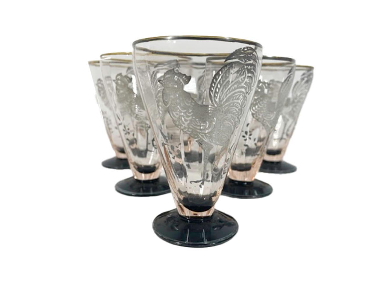 Six Art Deco cocktail glasses of pale pink optically ribbed glass with a silver overlaid rooster on a black glass foot.