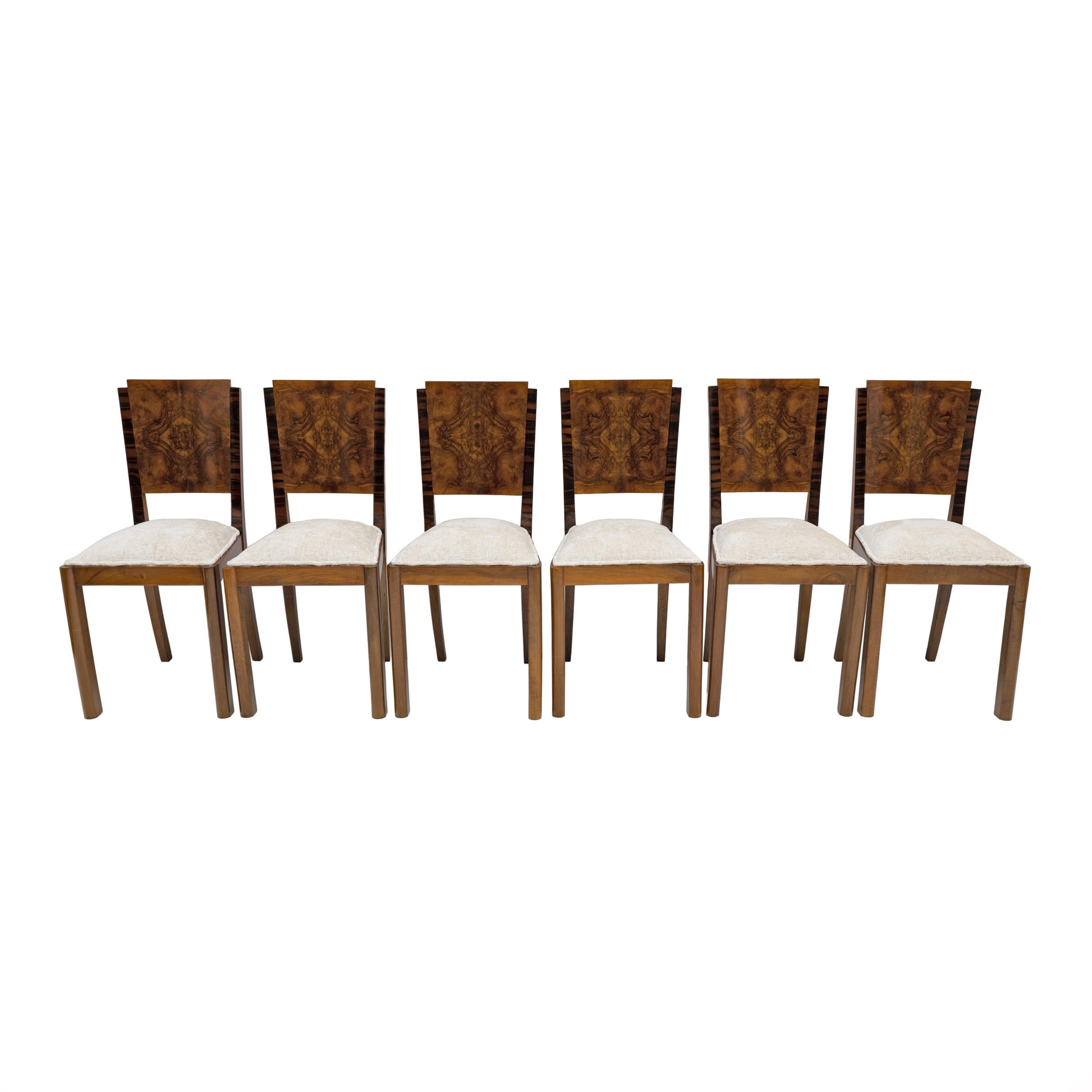 Beautiful Art Deco dining chairs. The frame is in walnut, while the backs have been veneered in walnut burl, famous for its sumptuous and dramatic patterns. The chairs have been upholstered in Bouclè fabric and restored with shellac polish. Made in