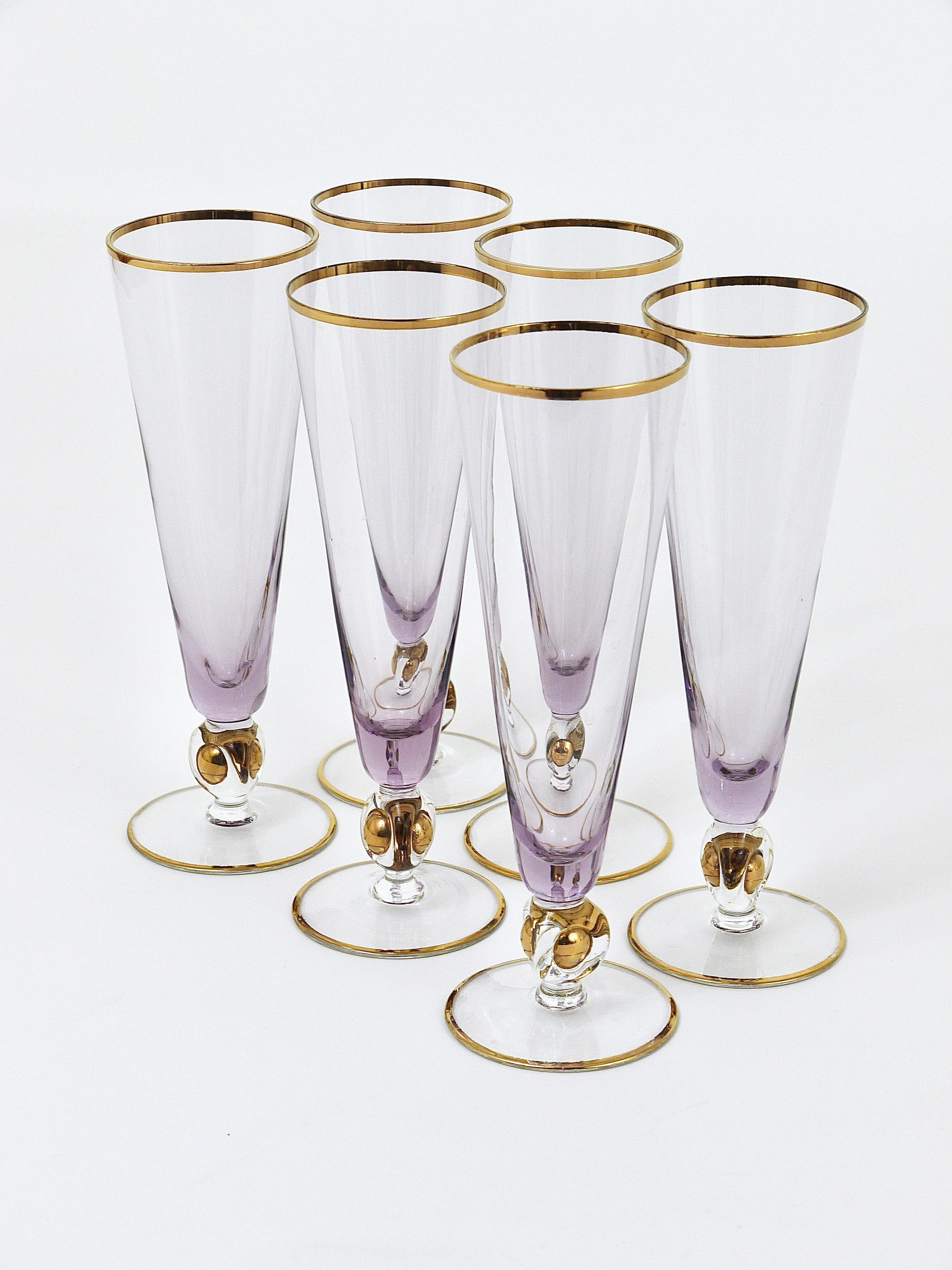 A set of six beautiful hand blown glasses for champagne or sparkling wine, made of clear and purple glass with gold rims and a golden ball in the stem. Made by Lyngby Glassworks in Denmark in the 1960s. In very good condition, with marginal partial