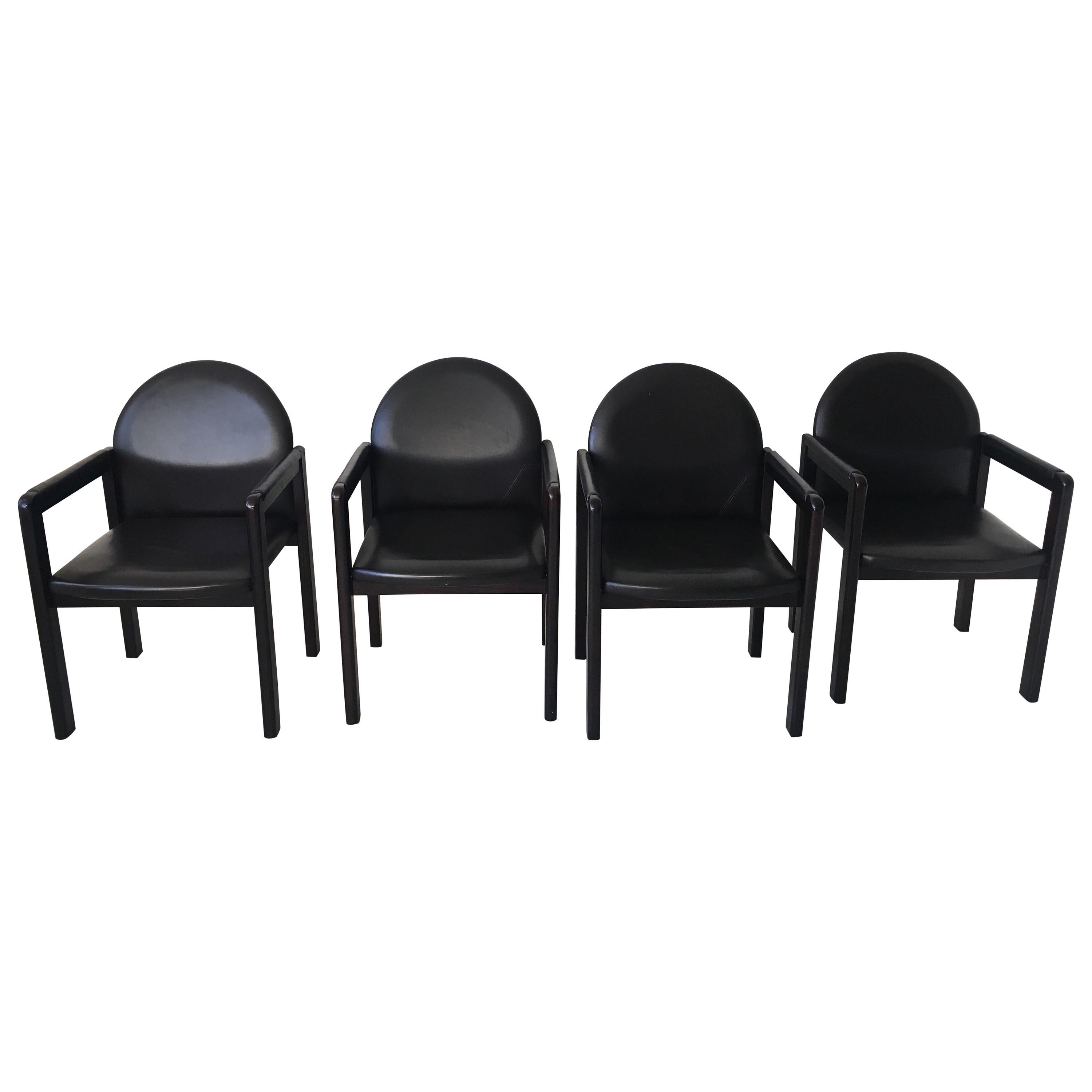 Six black leather armchairs manufactured by Bulo Belgium circa 1980s. The chairs feature a wooden base with Leather upholstery. They remain in a good and sturdy condition with some wear consistent with age and use like scratches to the wood and/or