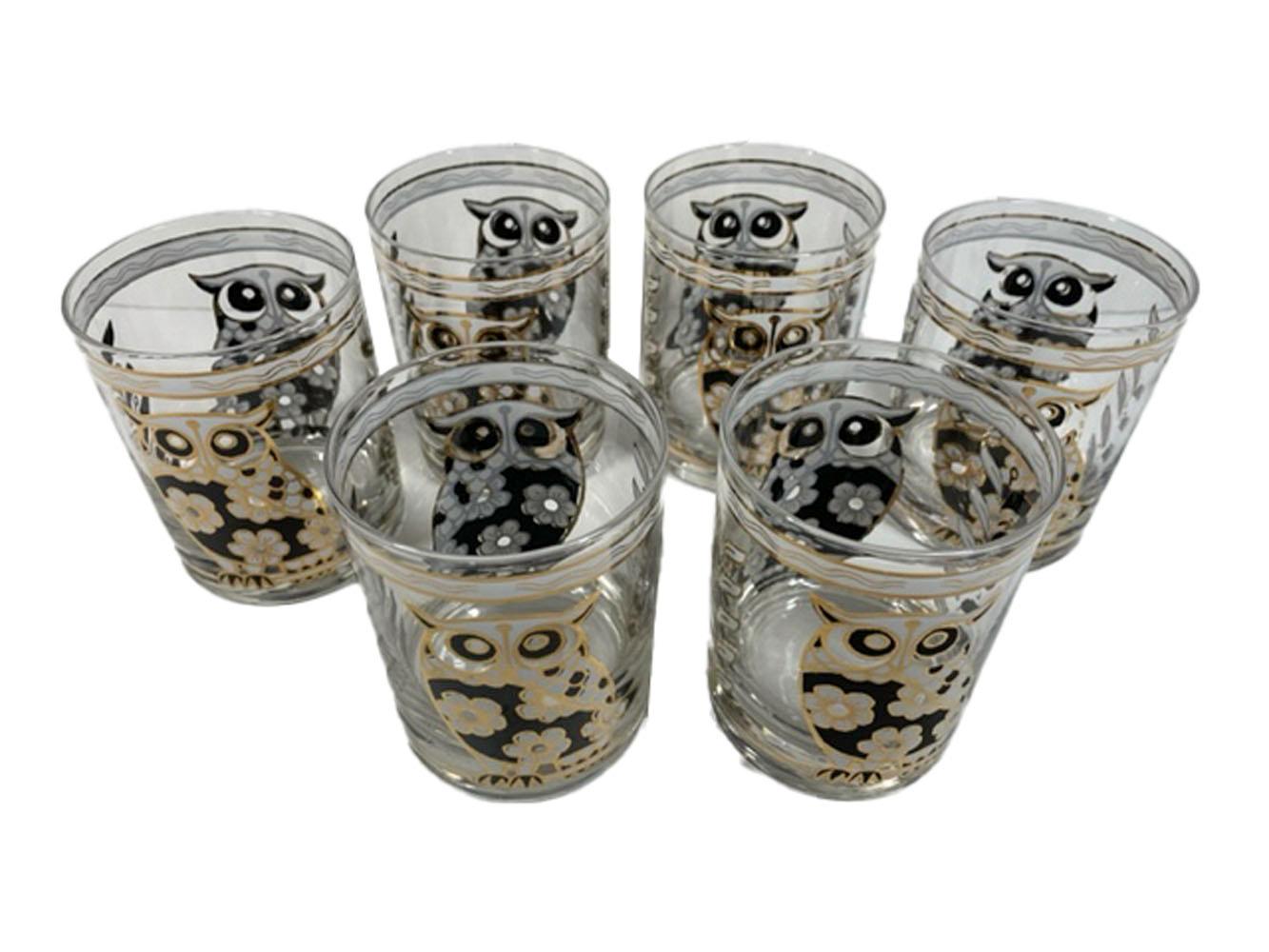 Six vintage rocks glasses by Cera Glassware decorated in black and white enamel with 22 karat gold detail. Each glass with an owl front and back, in black and white enamel with a pattern of cherry blossoms making up their bodies and accented with