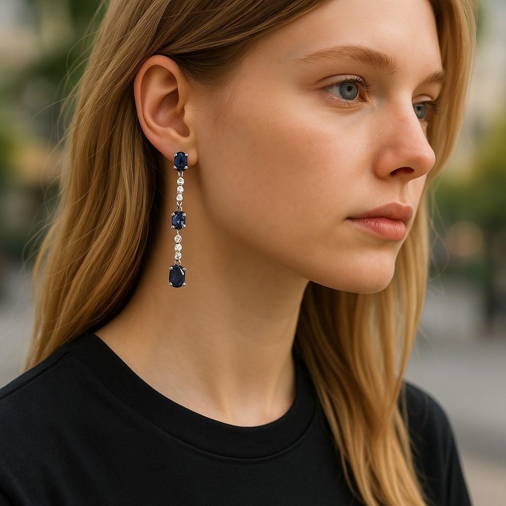 Nous vous présentons nos exquises boucles d'oreilles Lariat en or blanc 14 carats, composées de six saphirs de Ceylan assortis d'un poids total de 6,70 carats. Ces boucles d'oreilles sont un véritable chef-d'œuvre d'élégance et de sophistication et