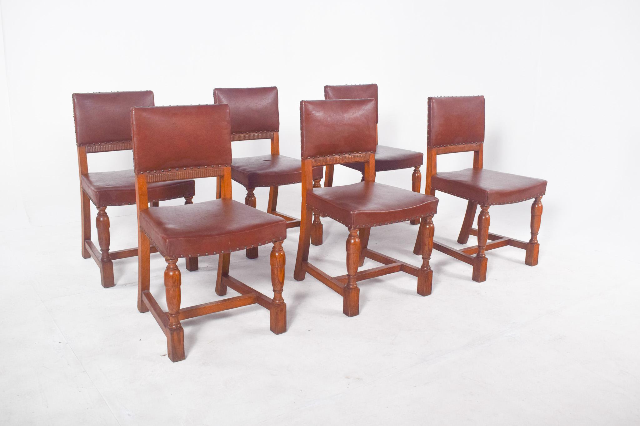 Six chaises avec dossier et assise en cuir marron. Les chaises ont un style simple mais élégant, avec des clous métalliques qui décorent et maintiennent les bords du revêtement, renforçant la tenue du cuir et ajoutant une touche d'artisanat. Les