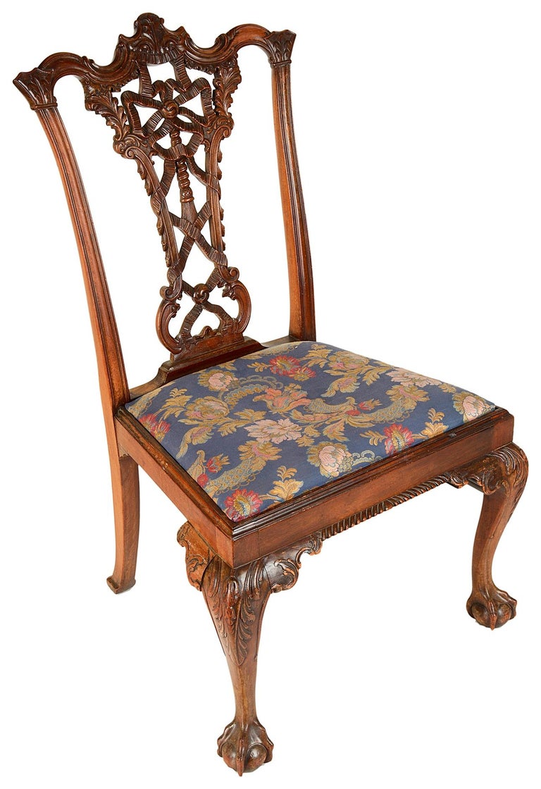A very good quality set of six (two arms and four singles) Chippendale style mahogany ribbon back dining chairs. Each with finely carved back splats of foliate, ribbon, swag and tassel decoration. Drop-in upholstered seats, raised on carved cabriole