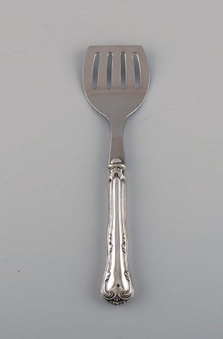 Six Cohr serving parts in silver and stainless steel. Mid 20th century.
Spade length: 19 cm.
Bottle opener length: 10 cm.
Stamped.
In excellent condition.
Our skilled Georg Jensen silversmith / goldsmith can polish all silver and gold so that