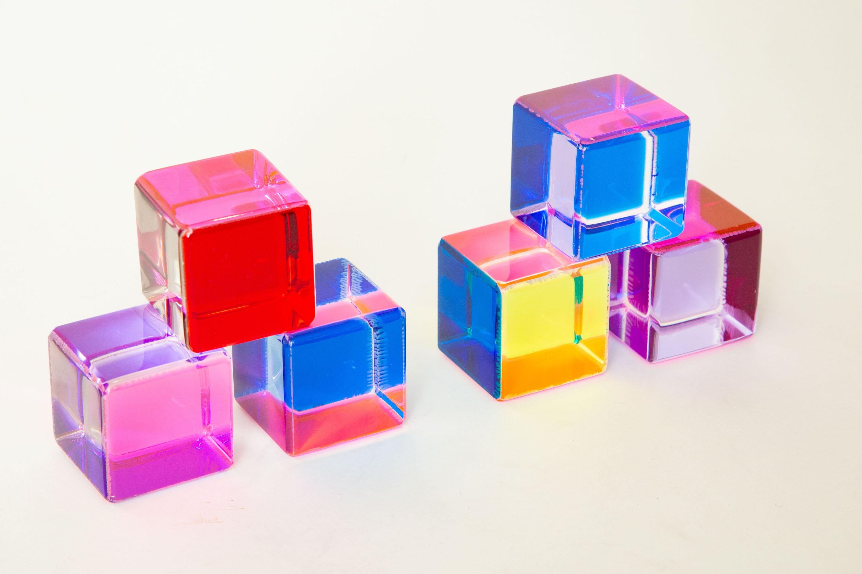 This set of six unsigned Vasa Mihich laminated square lucite cube sculptures are from the 1990s. The colors change with the play of light and planes of movement. Predominant colors are purples, pinks, reds, yellow, blue, orange and etc. They are