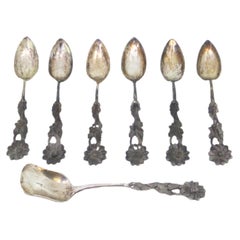 Six cut-silver teaspoons and sugar scoop with floral relief handles