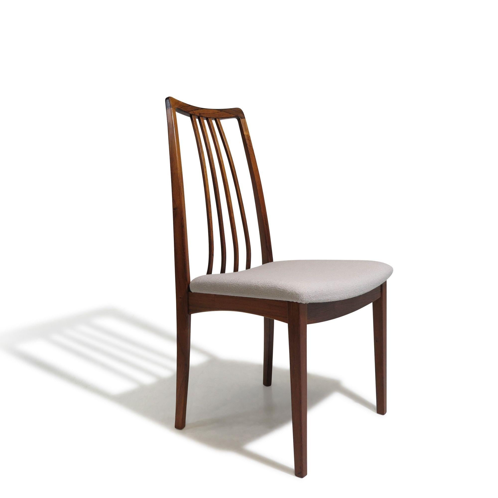 Set of 6 mid-century Brazilian Rosewood high-back dining chairs with elegant spindle backrests and newly upholstered seats in an off-white wool textile. The chairs have been fully restored and are in excellent condition, with minor signs of