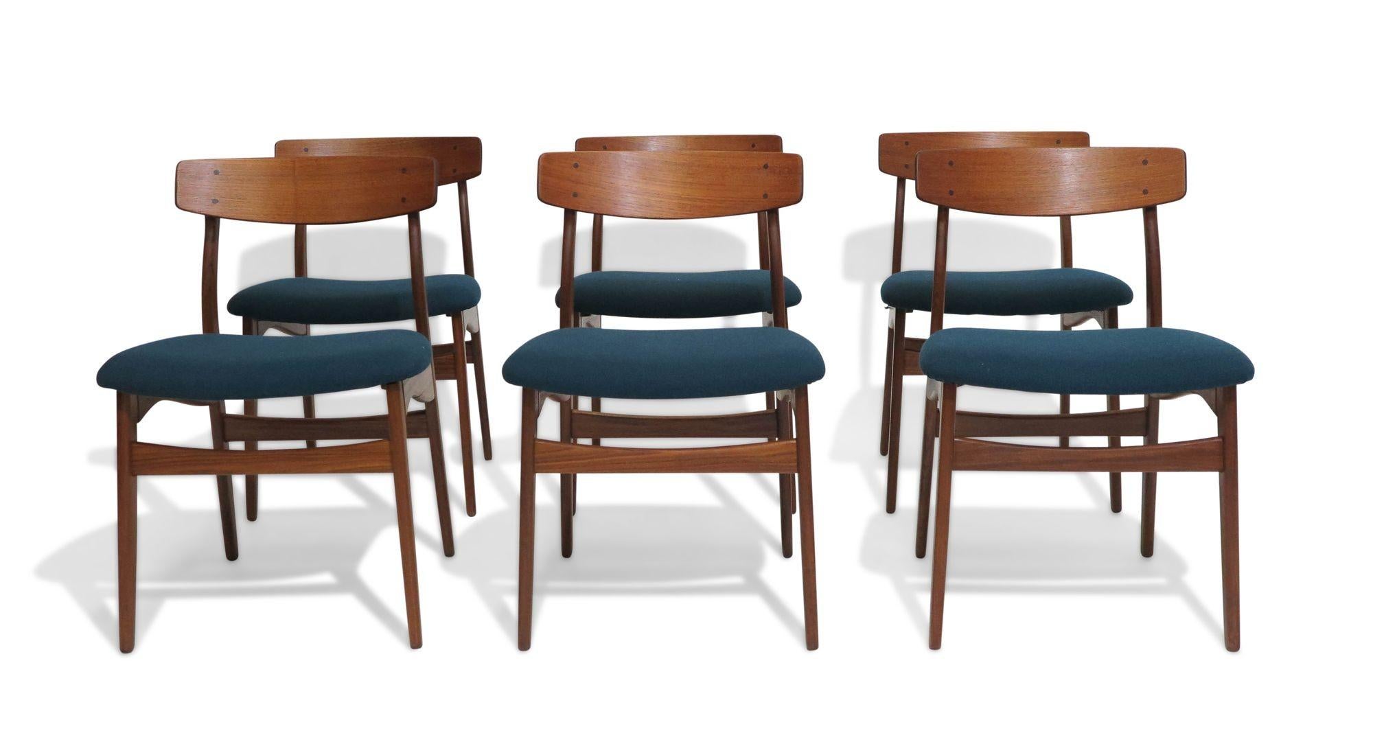Six mid-century Danish teak dining chairs handcrafted in Denmark of solid old-growth teak with sculpted back rest with exposed dowel joinery and newly upholstered seats in teal/blue wool textile. The wood has been professionally restored by our team