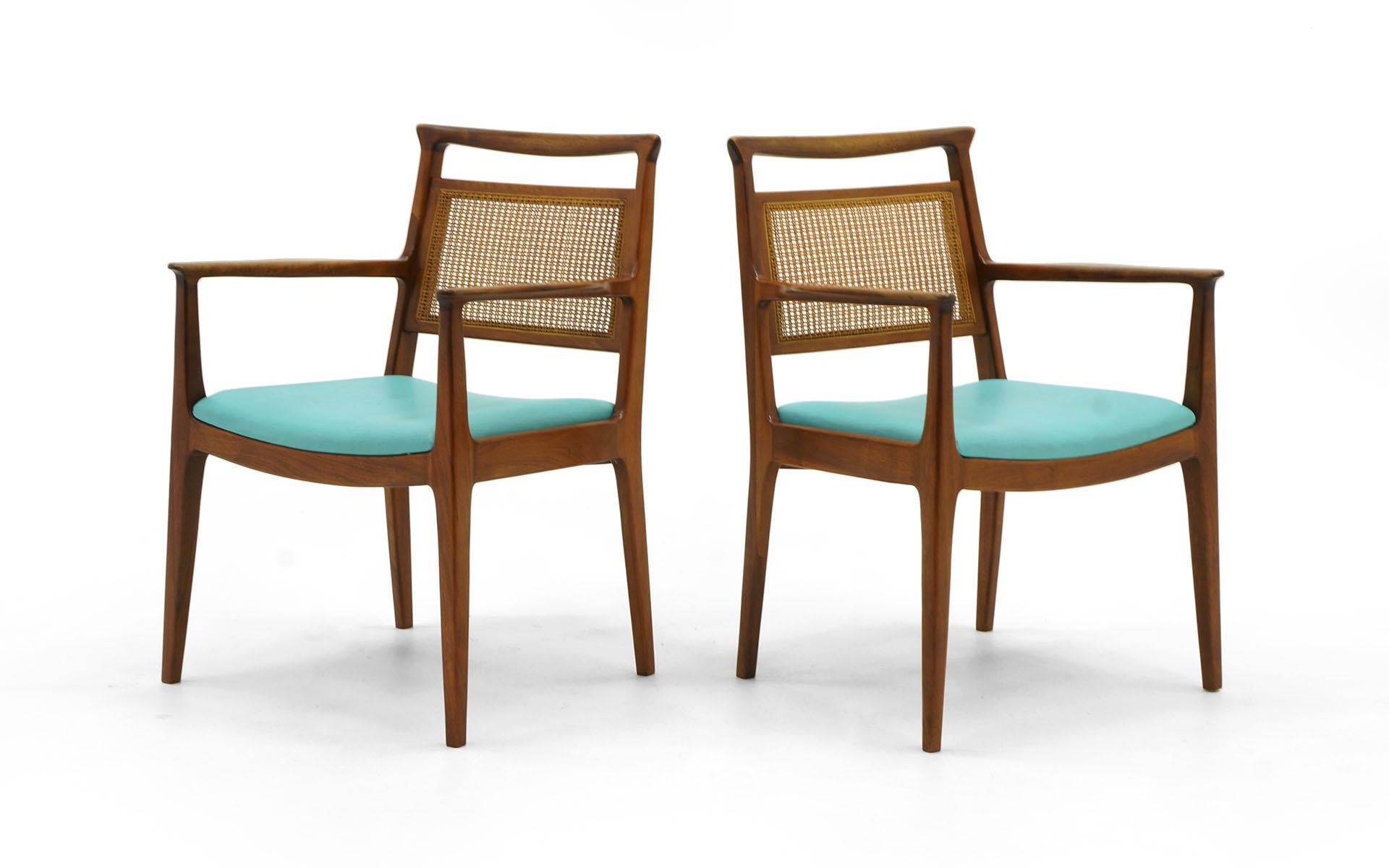 Set of six dining chairs designed by Edward Wormley for Dunbar. Two armchairs and four side chairs. Original solid walnut frames and cane backs are in excellent condition. The seats have apparently been reupholstered in light blue vinyl some years