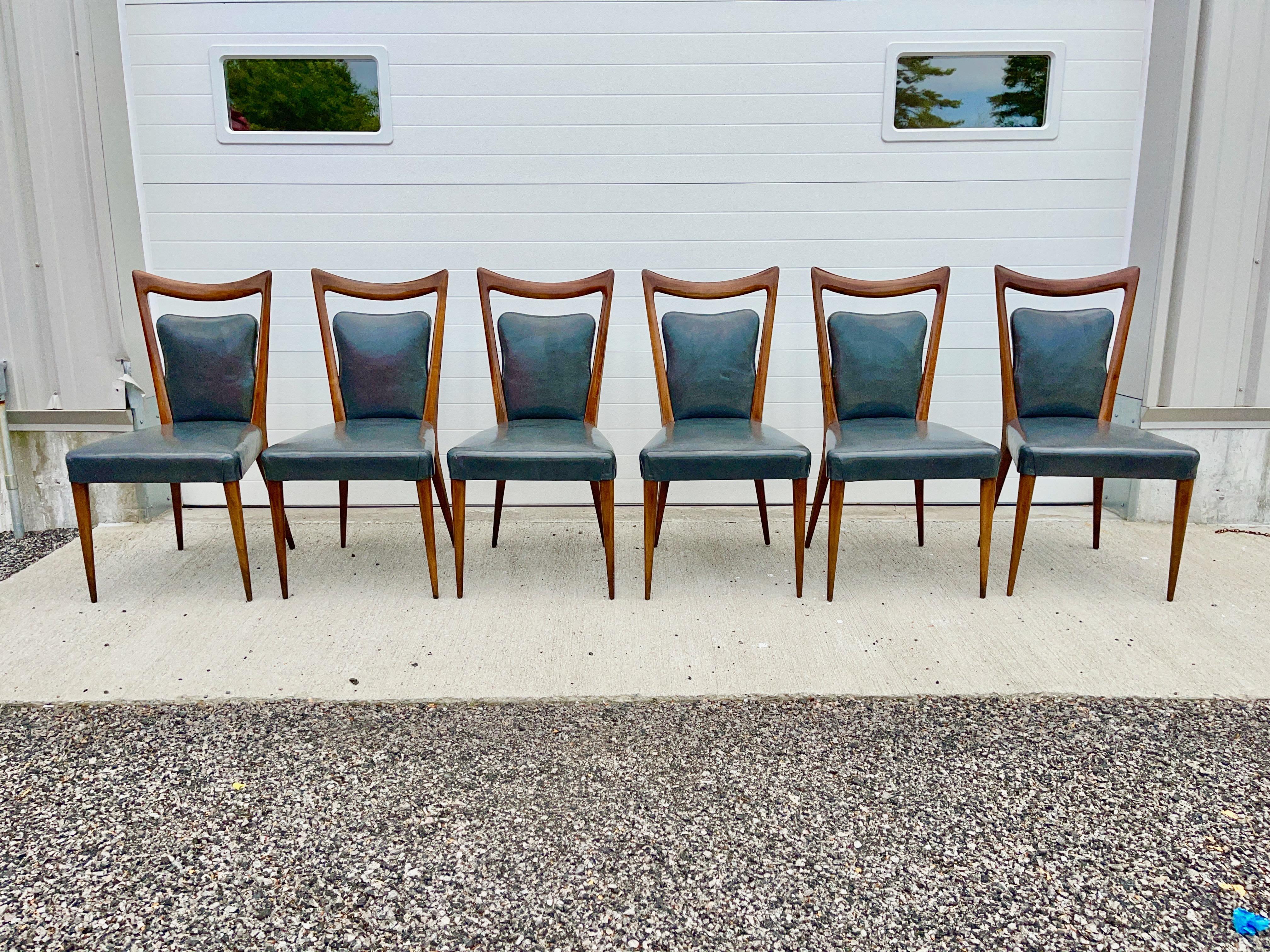 Set of six walnut dining chairs with seats and backs in slate gray leather designed by architect Mario Gottardi and produced by Melchiorre Bega Italy. These were exported to and supplied by Enro Fabry Associates of New York. 
Known as model 614