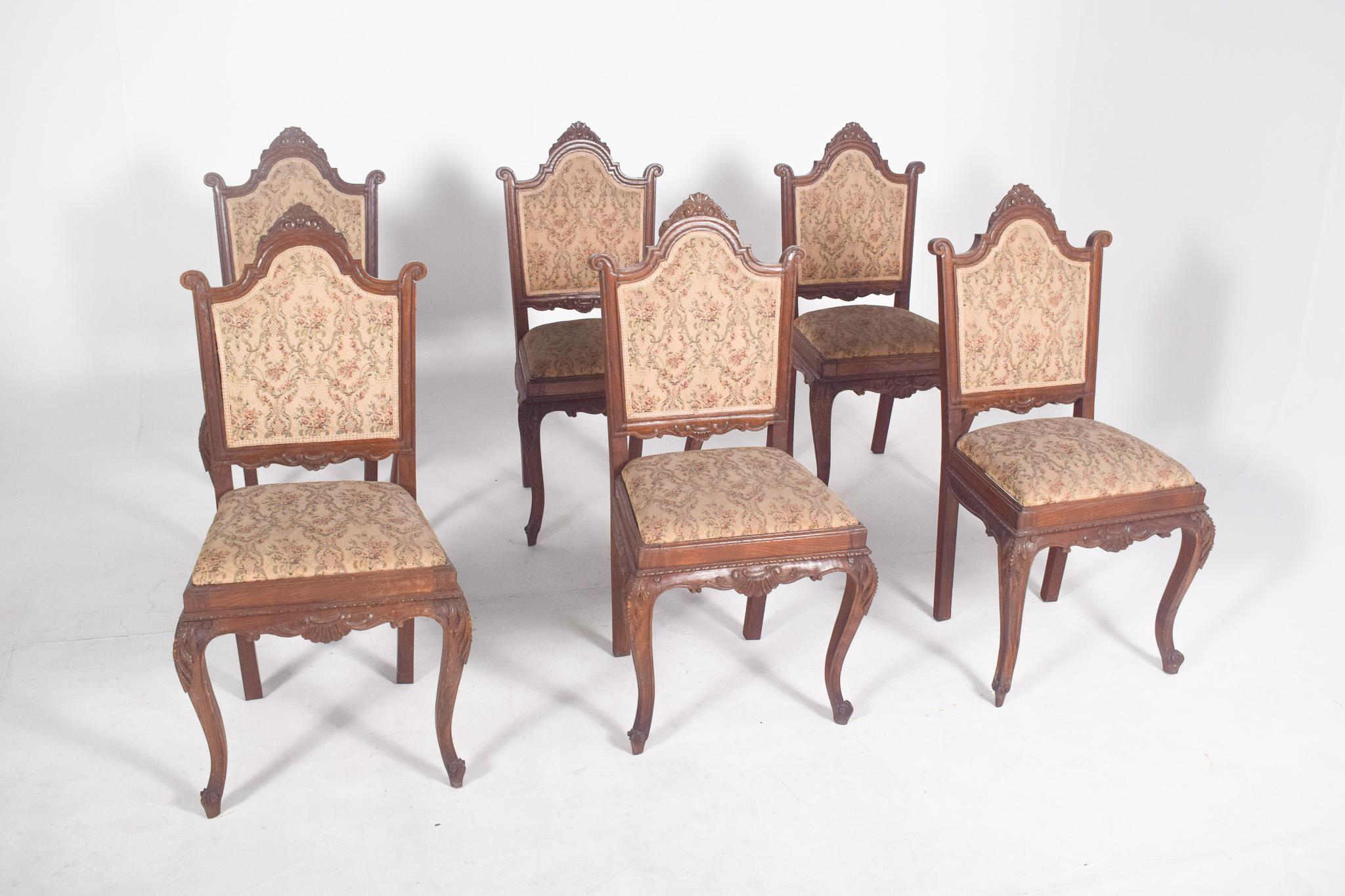 Seis sillas de comedor de estilo Luis XV.  En madera tallada, de influencia francesa de finales del siglo XIX, respaldos altos enmarcados por un perfil curvo y recortado superior con volutas laterales, medallón central tallado, tapizado en tela