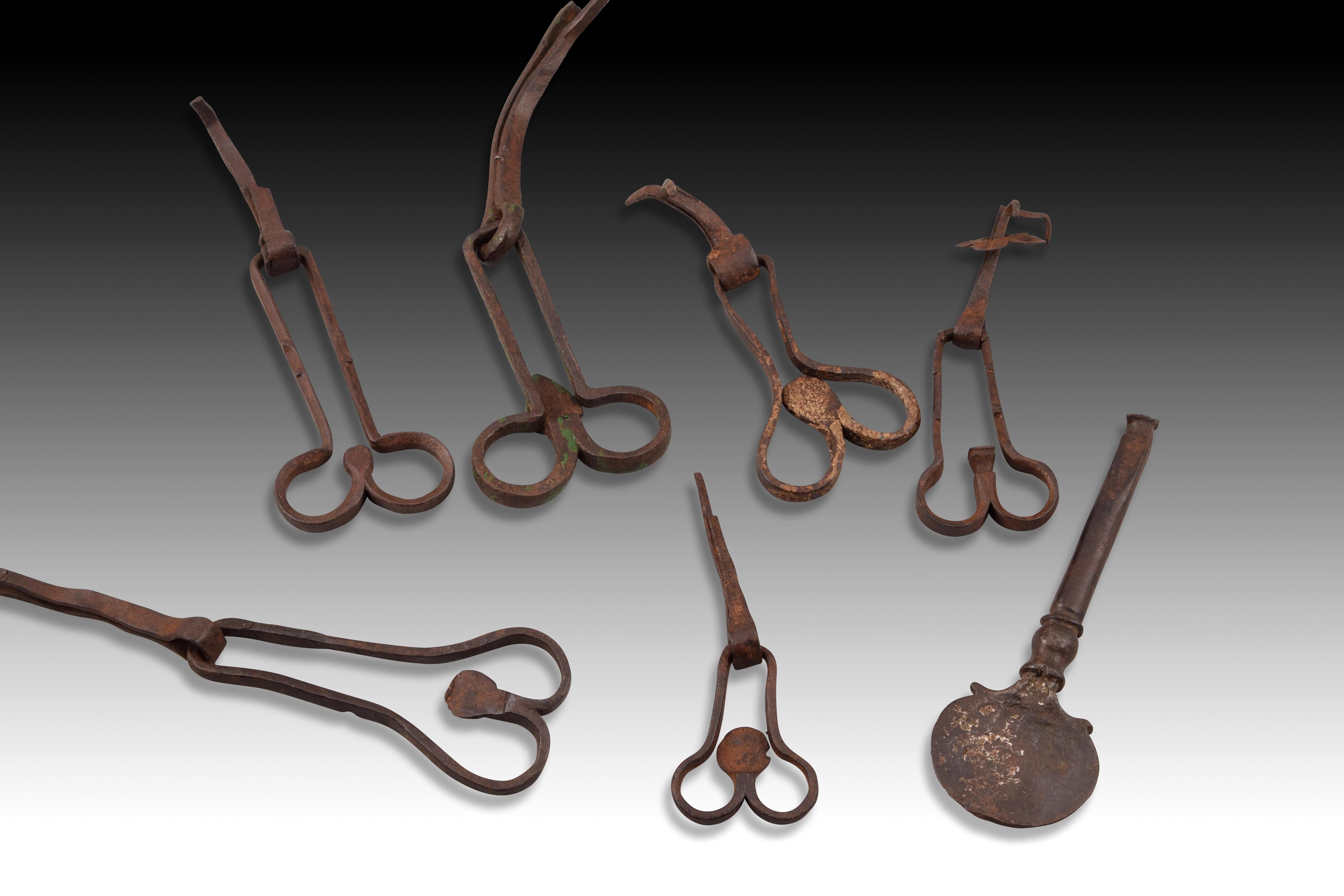 Set of six scissor and latch handles. wrought iron Century XVI. 
Lot consisting of six wrought iron pieces: six door handles of the type known for their scissorlike shape, with simple decorations; and a latch also decorated in its final part. ·