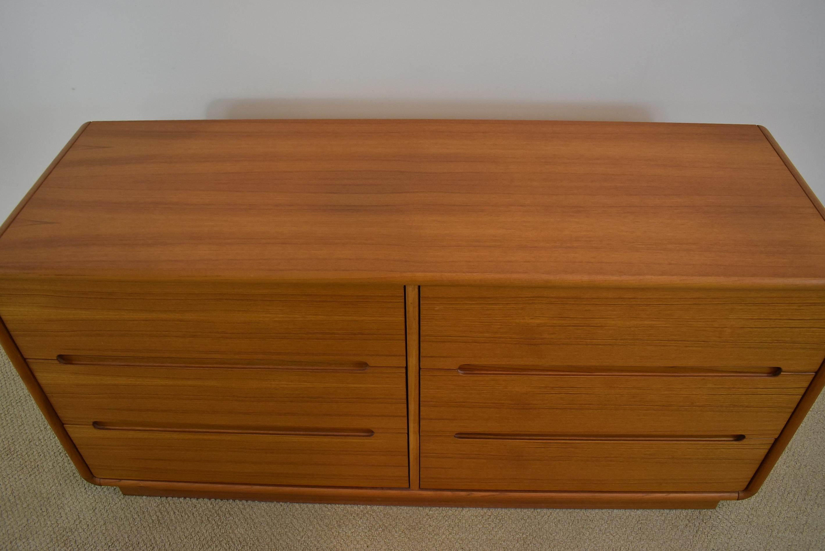 Six-drawer Mid-Century Modern teak chest platform base with a contoured design. The back is finished. Very nice condition. 57.5
