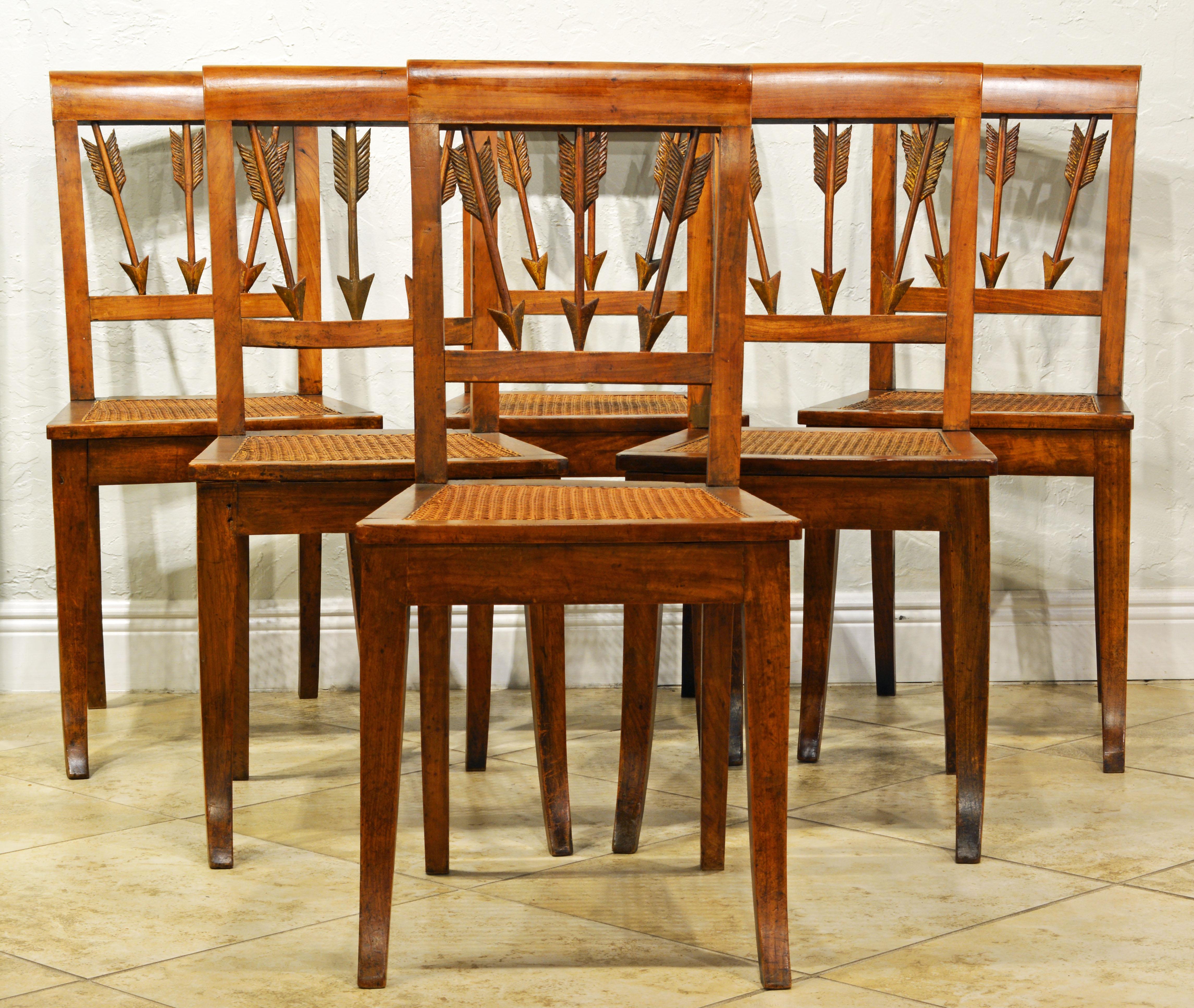 These neoclassical dining chairs are likely made in Northern Italy under influence of Austrian craftsmanship. The klismos form as well as the carved arrow shaped back splats reflect classical tradition. The wood is likely to be cherry wood. The