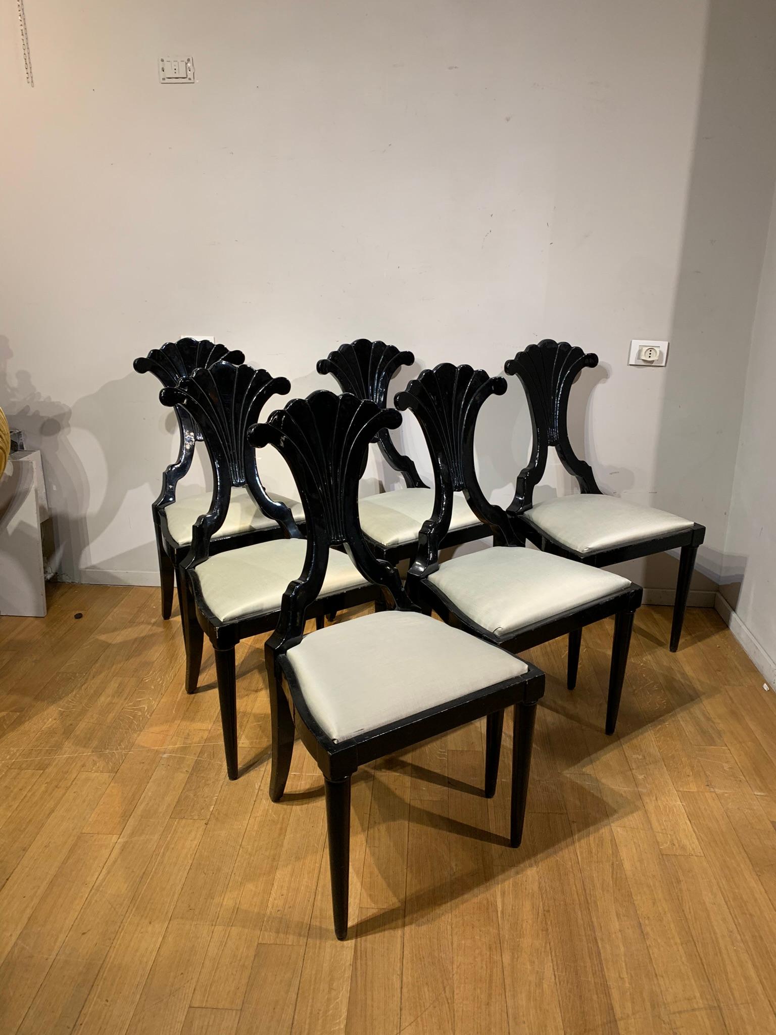 Beautiful and elegant set of six chairs in ebonized wood with a chalky background typical of mid-19th century French manufacture. Truncated conical legs and back in the shape of a stylized cornucopia. Since they are also carved on the back, they are