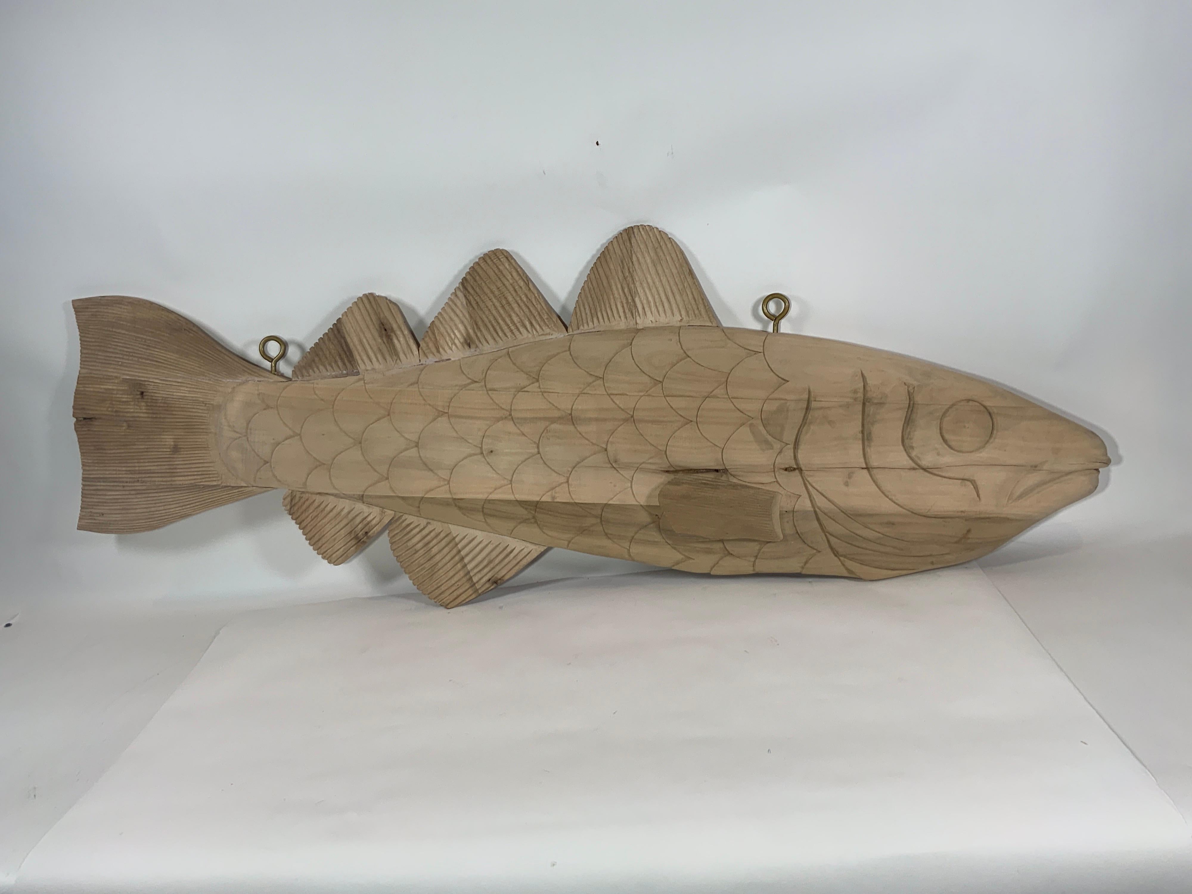 Carved wood codfish trade sign reminiscent of the signs that used to hang in the English fish terminals in the 19th century. Detailed carving with gills, fins, scales, eyes and snout. Two sided. Fitted with hanging hooks.

Overall Dimensions: