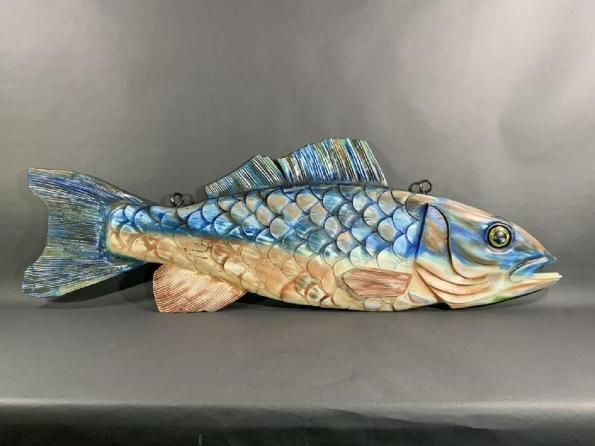 Intricately carved hanging wood fish. Carved with gills, eyes, fins etc. Colorfully painted in blues and cream.

Overall Dimensions: Weight is 42 pounds. 24