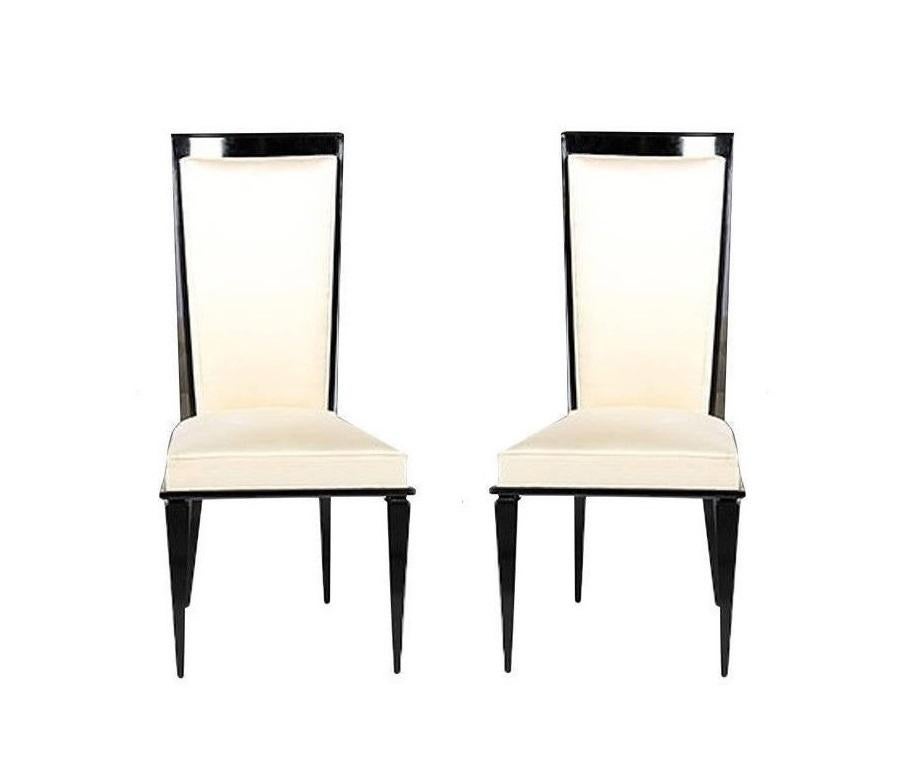 Elegant set of Art Deco dining chairs in the style of Maurice Jallot, Jules Leleu and Jean Pascaud. The chairs boast solid wood frames refinished in black lacquer with high backs and seats professionally reupholstered in a white cream color. They
