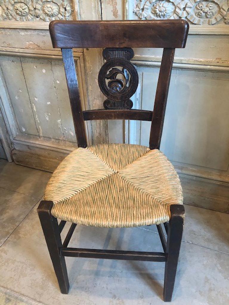 Set of six French carved walnut rushseat dining chairs, early 20th century, the curved crest rails over pierced circular splats, to rush seats, on tapered square legs joined by stretchers, Measures: H.- 34 in., W.- 17 in., D.- 14 in.