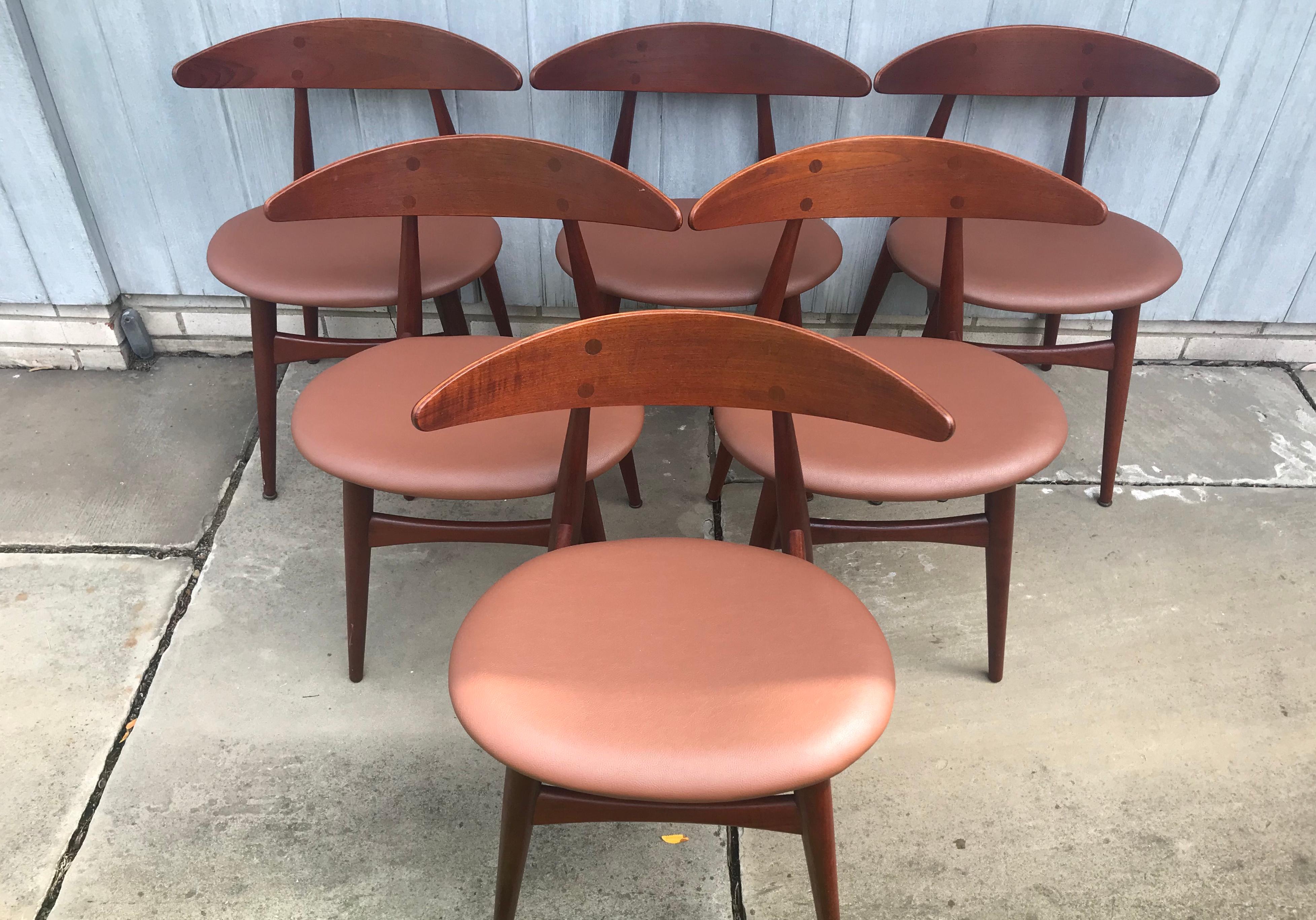 Beautiful set of 6 teak dining chairs in teak. Model CH33 chairs, in teak and reupholstered in Maharam “lariat” vegan leather color “russet” textile. Deep brilliant color and sculpturally formed frame.