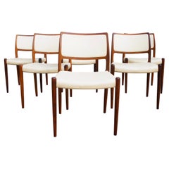 Six hardwood Niels Moller Model 80 Chairs, with cream vinyl upholstery