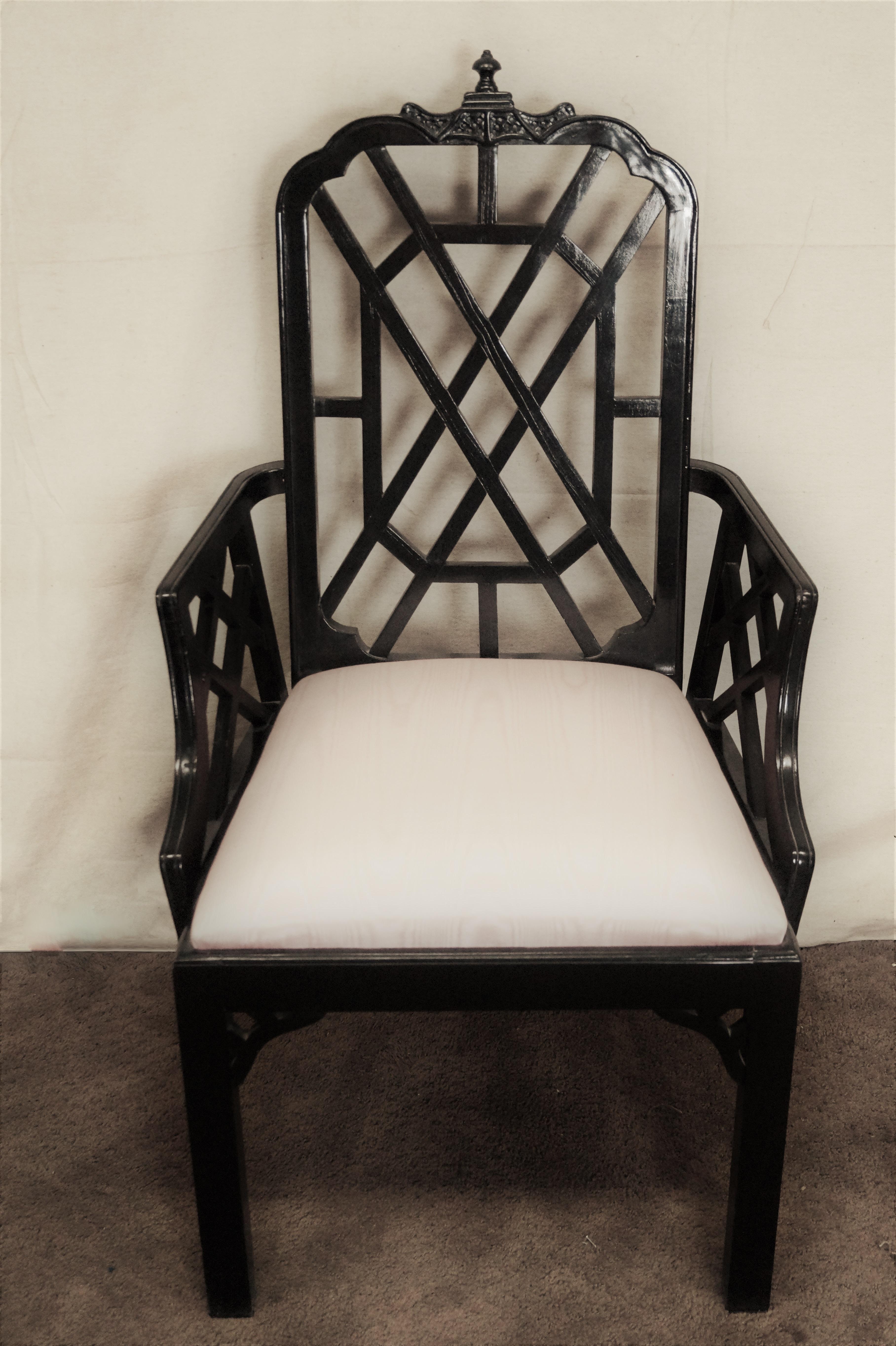 Set of six Classic chinoiserie inspired dining chairs. The set has 2-arm and 4 side chairs, feature a pagoda detail to the top rail with elegant fretwork on backs with armrests raised on matching lattice, raised on block form legs. The frames are