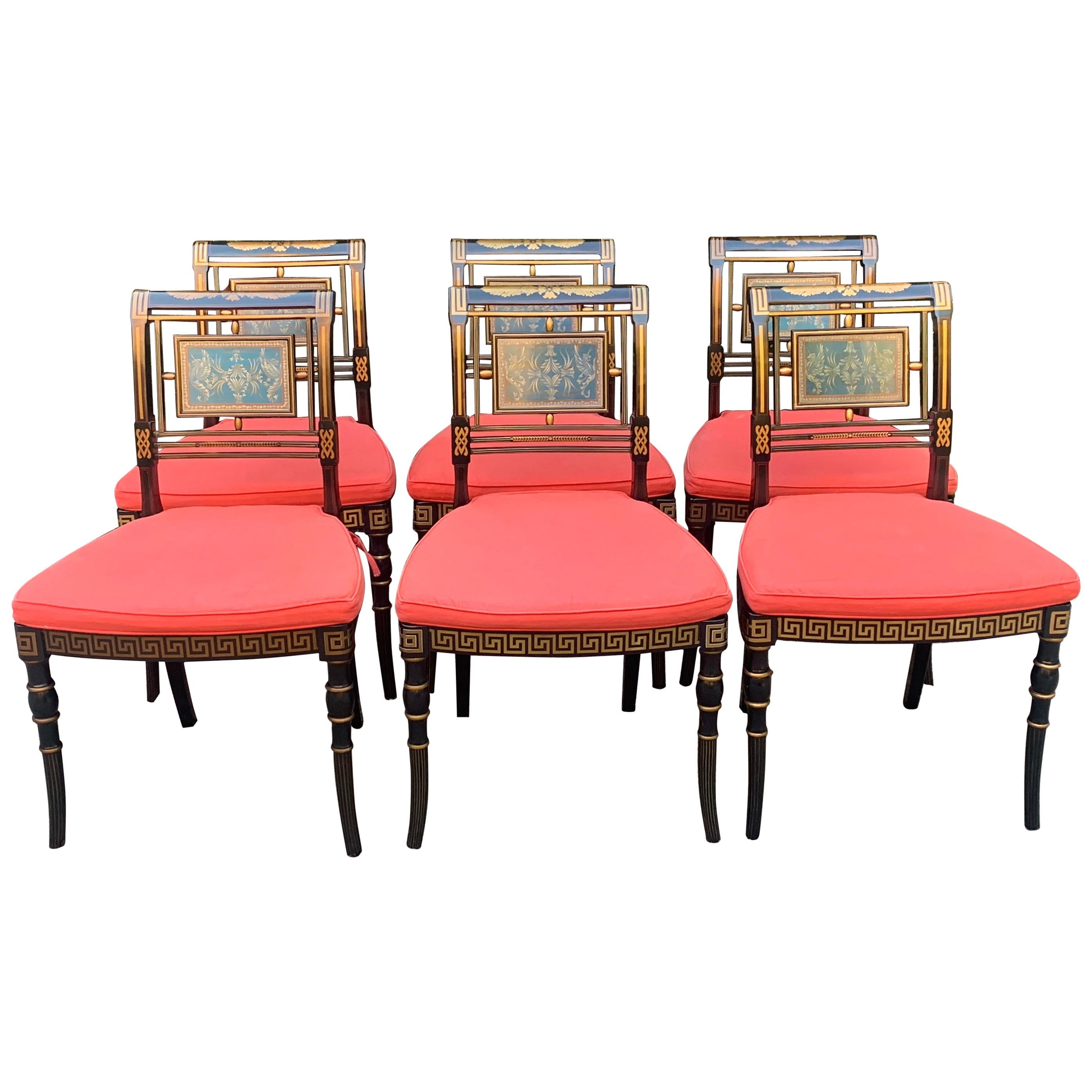 A set of six exquisite Hollywood Regency dining chairs with cushions. The chairs are hand painted, black lacquered, with cane seats and custom cushions in orange. Perfectly emulating the Hollywood Regency style. The added cushions come with ties and