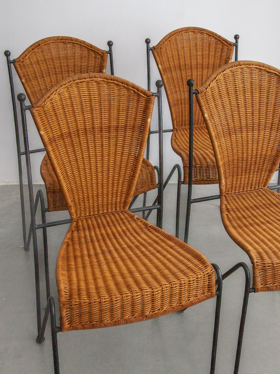 Vintage dining chair set indoor, outdoor dining chairs by designer Pipsan Saarinen Swanson for Ficks Reed. Sculptural black iron frames with gold ball ends. Woven rattan seats. Set of six chairs, two whith arm-rests. Dimensions: No armrests: 44W x