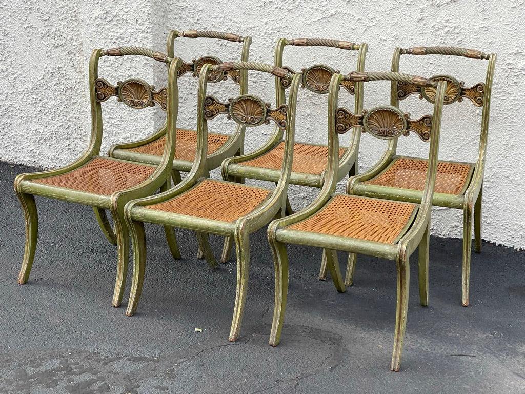 Six Italian 19th century klismos side chairs with elaborate shell-carved back rails, parcel-gilt and painted in green and cream. Caned seats, some with original needlepoint cushions included. Dimensions: H 33