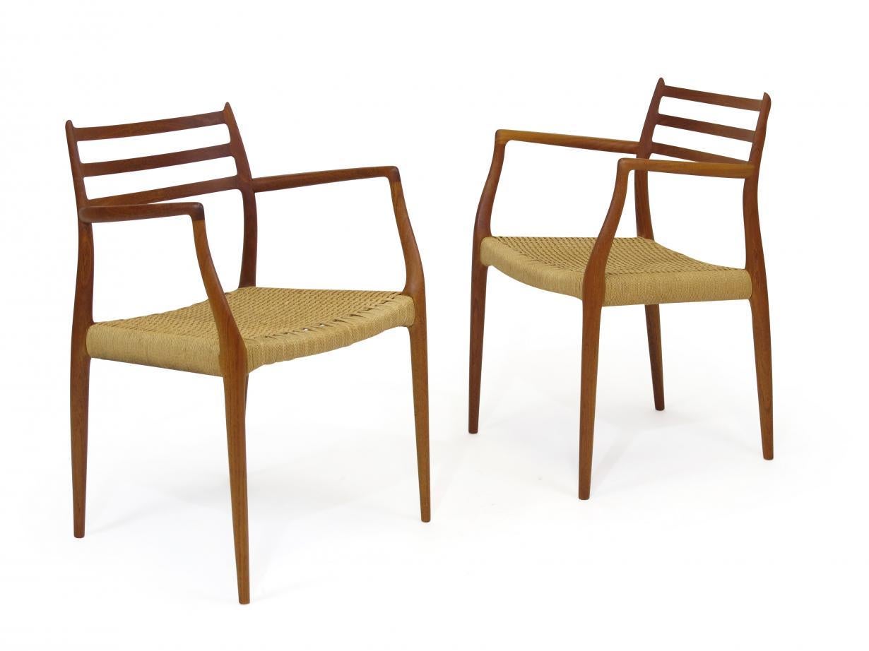 Set of six solid teak dining chairs designed by Niels Otto Møller for JL Møller. Includes four model #78 side chairs and two model #62 armchairs with a hand rubbed natural oil finish and original papercord seats. Two armchair measures: W 31.5 x D