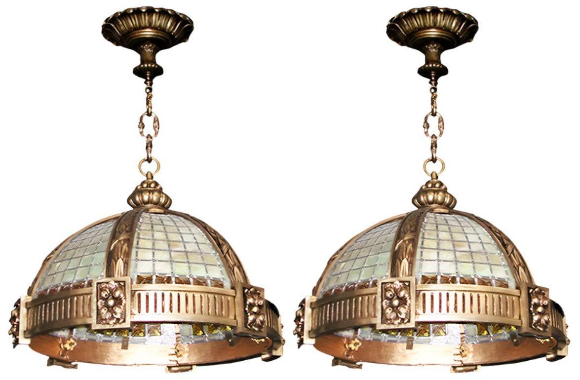 An exquisite Set of six Oversized Late 19th century French bronze pendants, beautifully crafted with stained glass panels and dramatic chunked amber glass trim. The heavy bronze framework is richly detailed, exhibiting elegant Gothic and Art Deco