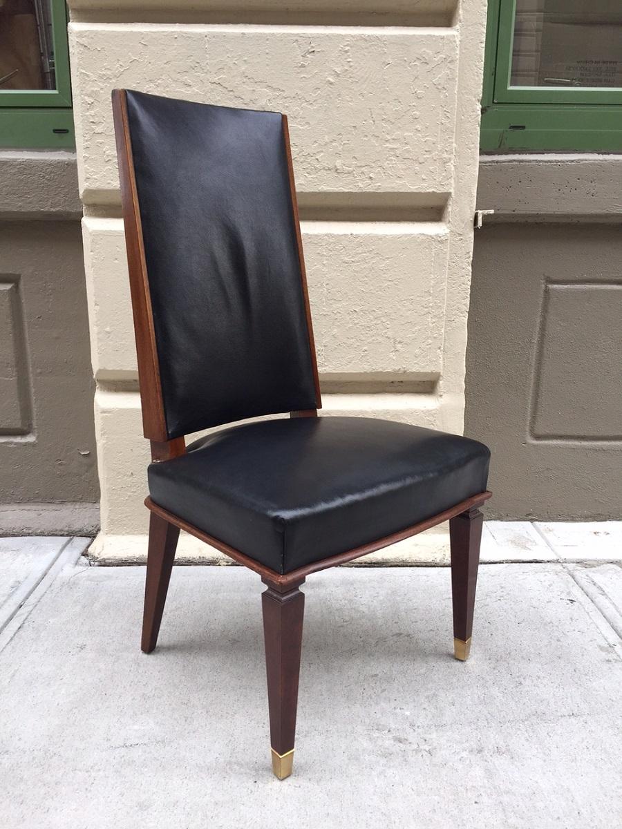 Set of six walnut and leather dining chairs in the style of Andre Arbus. Original leather seats with gilded bronze sabots. Leather is in good vintage condition.