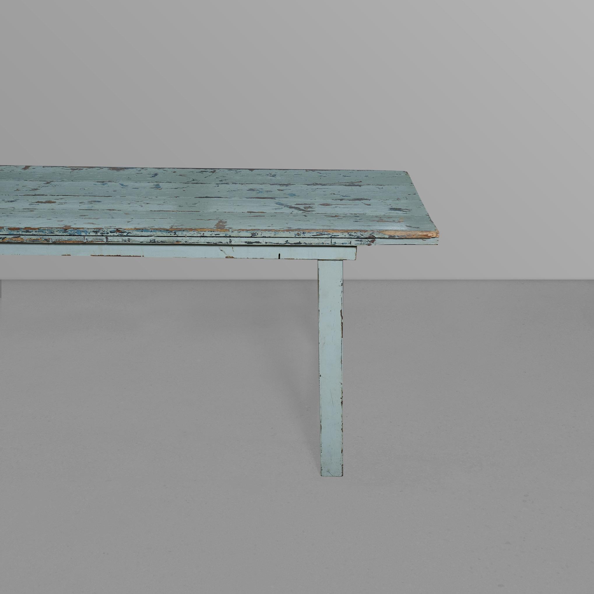 Tisch mit sechs Beinen, einem Eisengestell und einer wunderschönen blauen Holzplatte.

