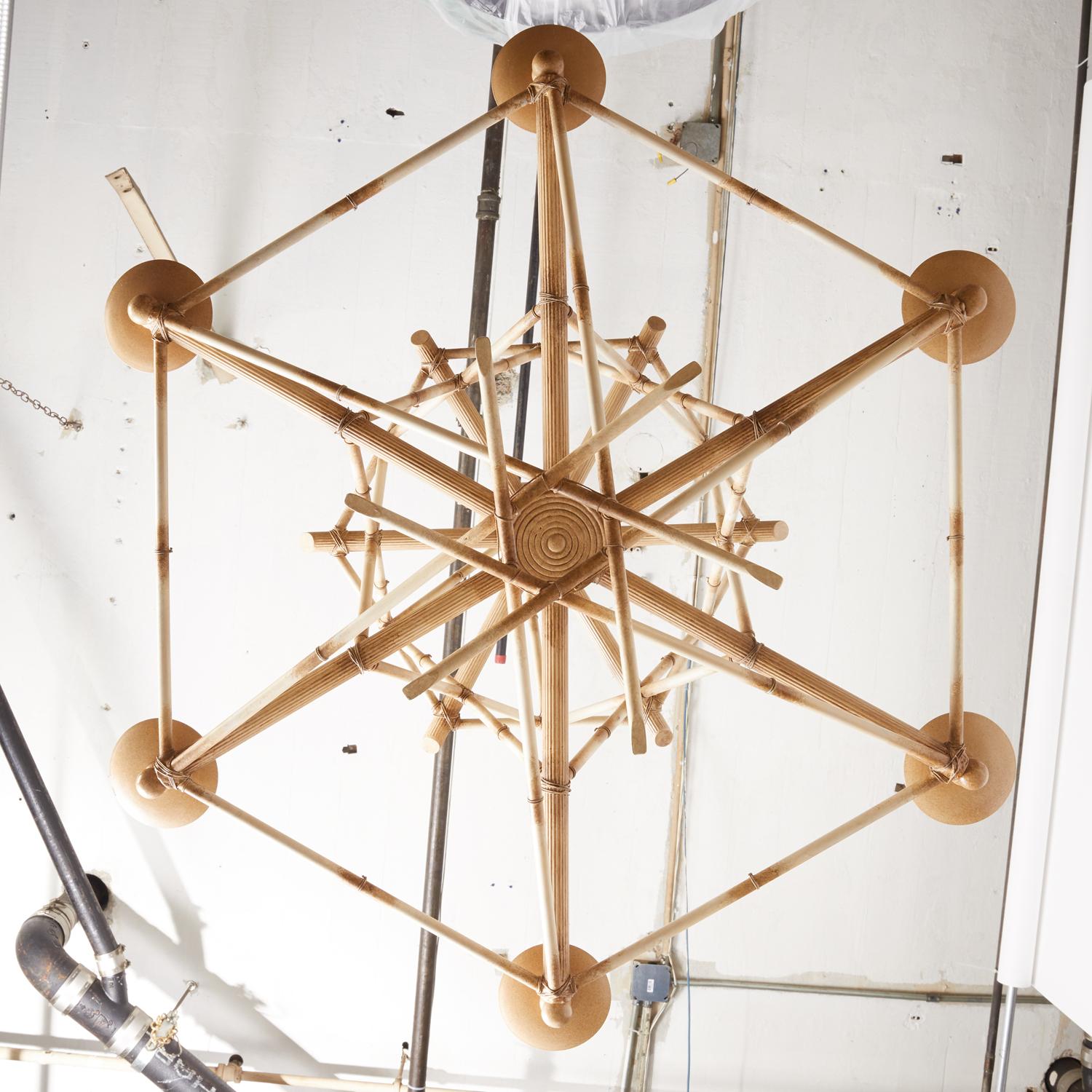 Ein sechsflammiger Kronleuchter aus falschem Bambus von David Duncan Lighting. Dieser Kronleuchter zeichnet sich durch eine spielerisch komplizierte geometrische Struktur aus, die aus gekreuzten Abschnitten aus handbemaltem Messing besteht. Diese
