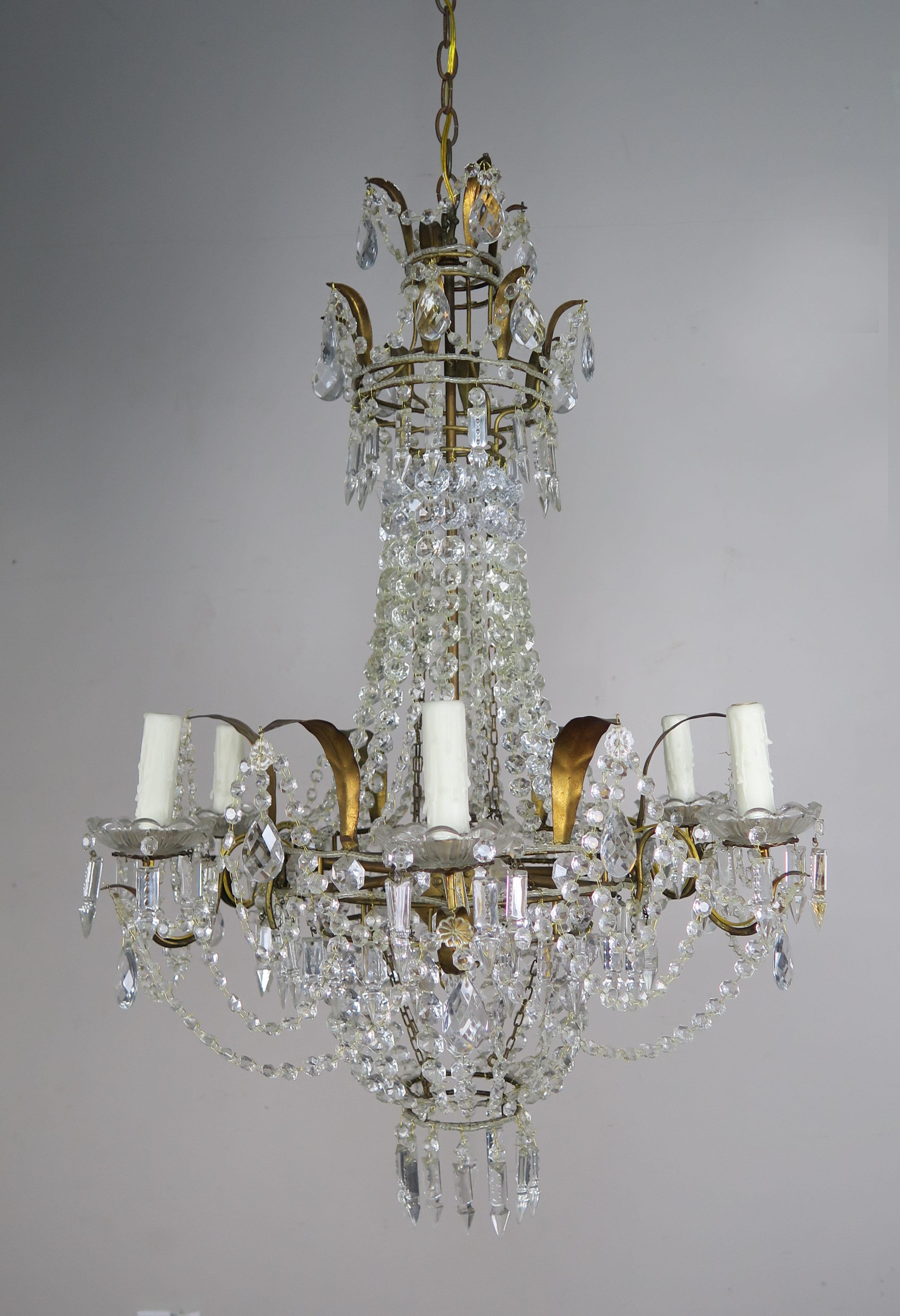 Lustre français à six lumières de style Louis XV en métal doré et perles de cristal avec des guirlandes de cristaux incorporées dans tout le luminaire. Les guirlandes forment des motifs uniques qui rendent ce luminaire différent de tous ceux que