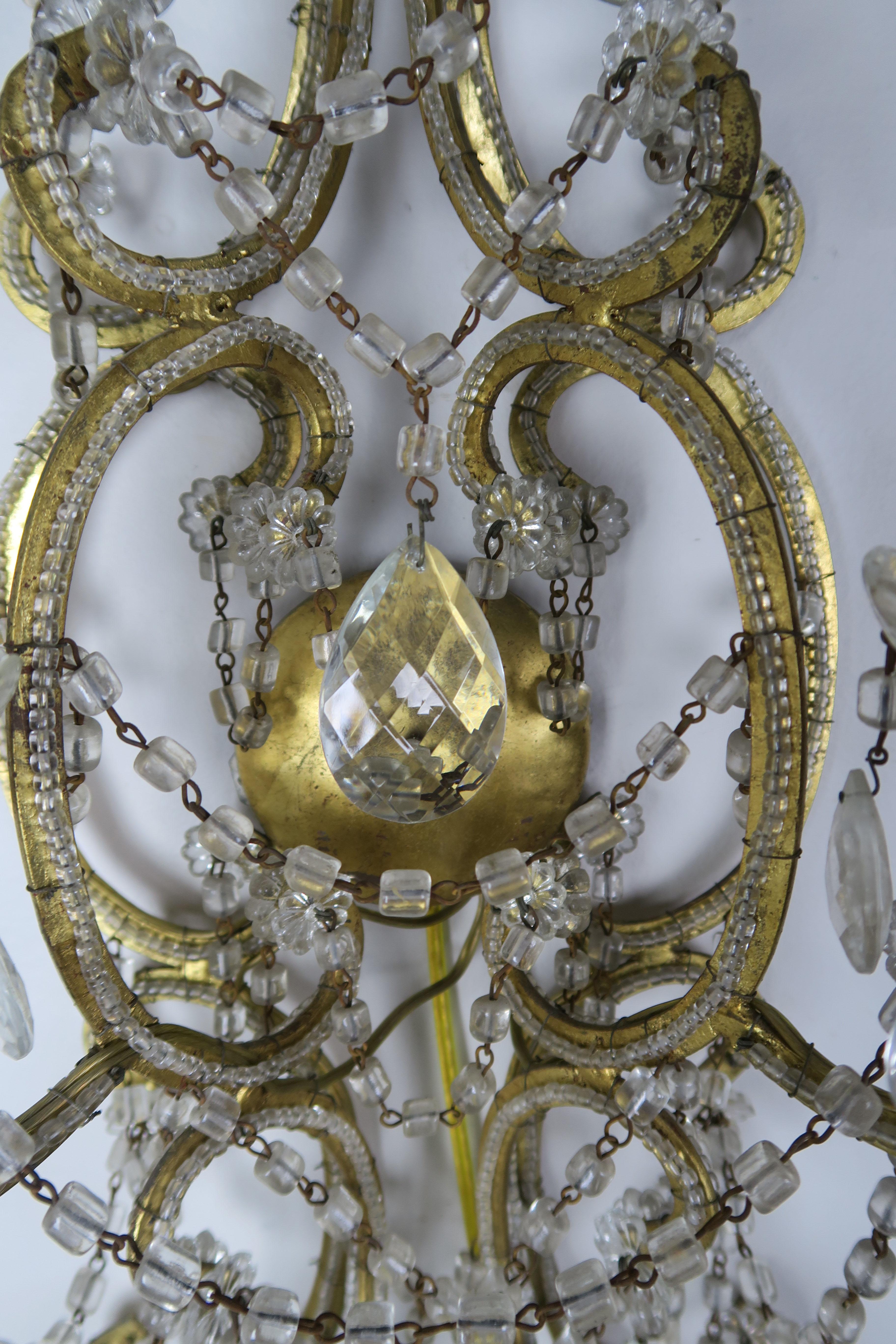 Six-light Italian beaded crystal sconce adorned with garlands of macaroni beads and crystal pendulum drops throughout. The sconce is newly rewired with cream colored drip wax candle covers. Ready to install.