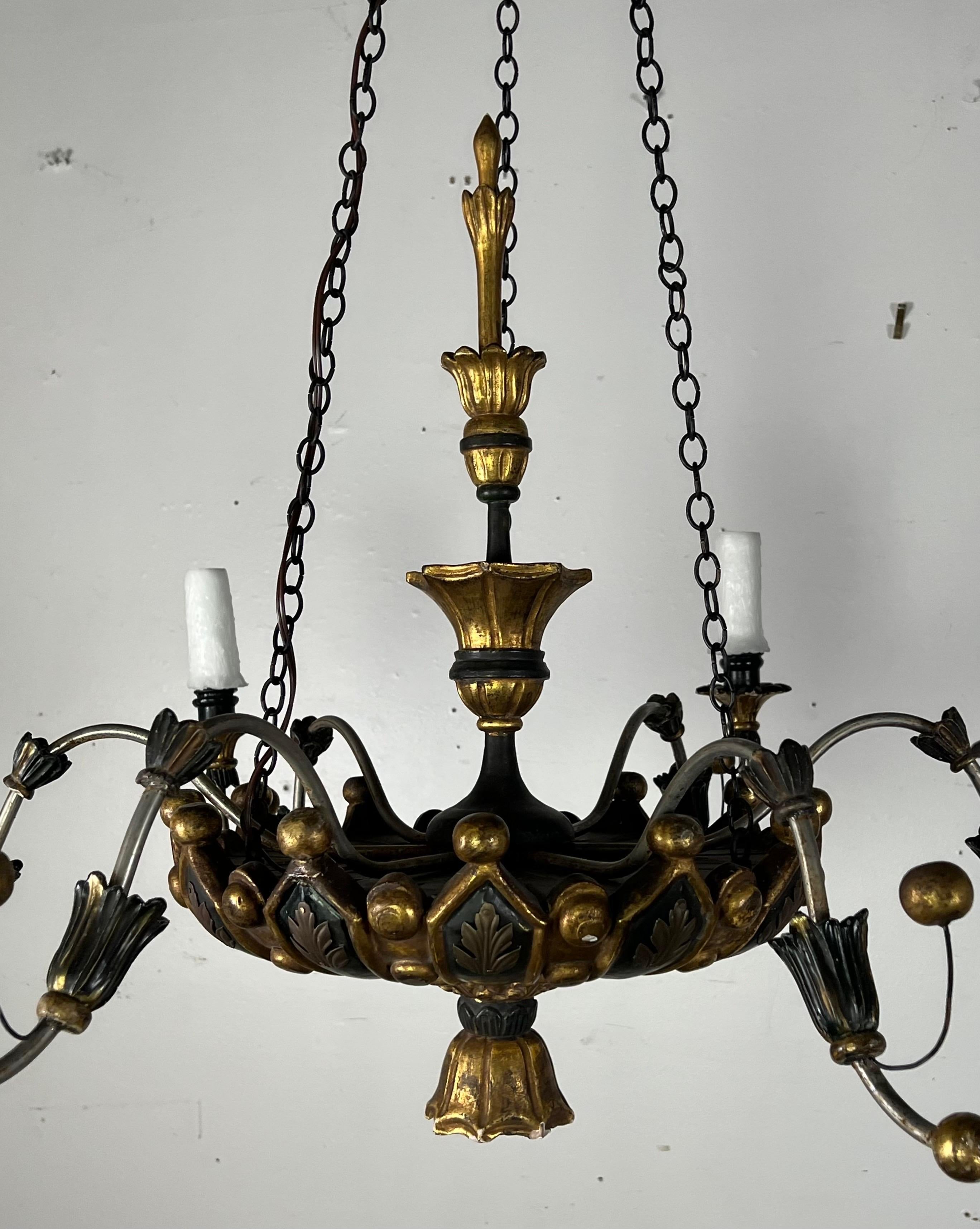 A six-light Regency style chandelier featuring intricate carved and painted details, blending historical aesthetics with modern functionality.  The Regency style, know for its elegant and refined decoration, often includes motifs such as acanthus