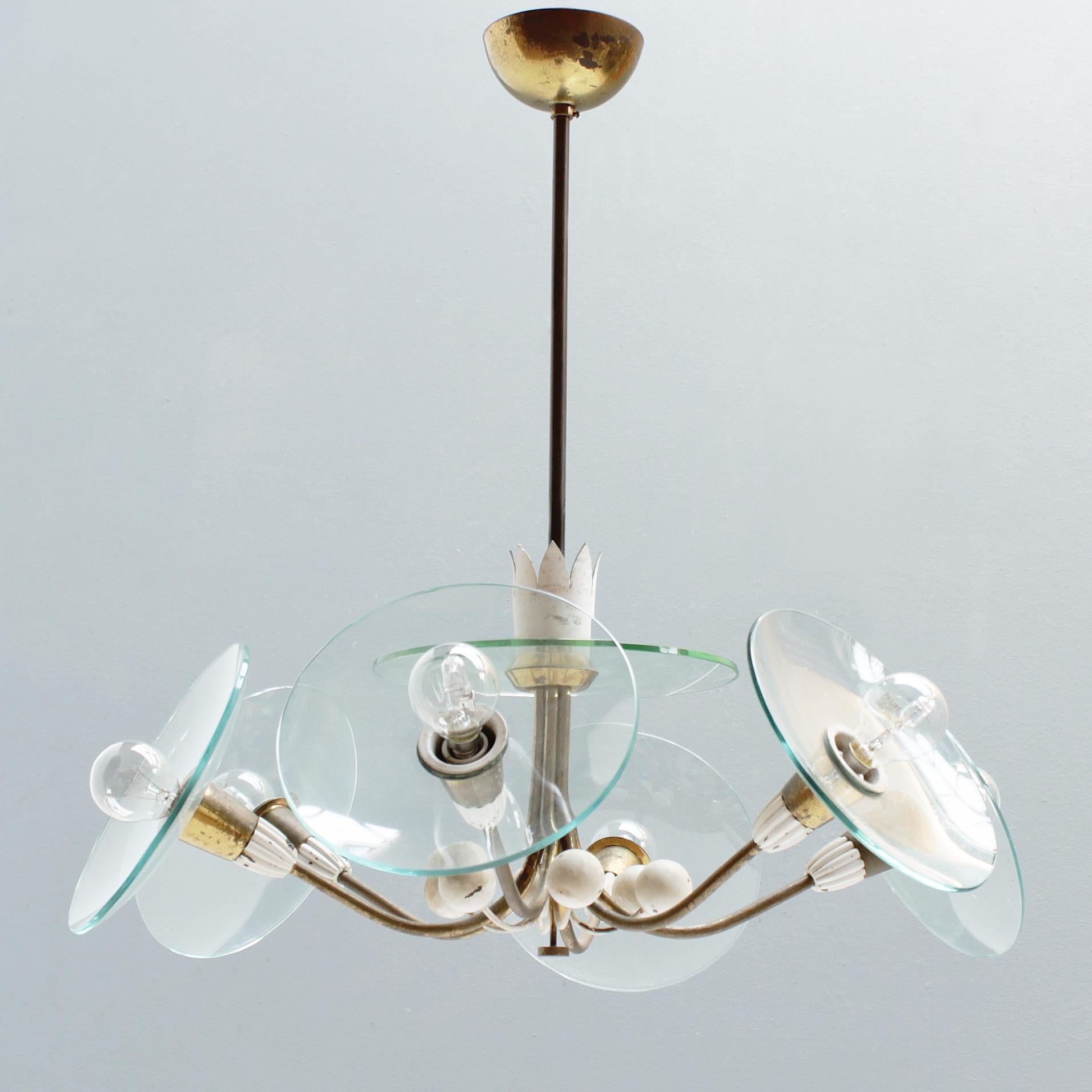 Elegant 6-lights chandelier attributed to Pietro Chiesa for Fontana Arte, Italy. Period 1940-1949. Rewired but in an original condition with a beautiful patina. Brass, partially painted white and crystal discs.
Six small bulbs, Edison Screw (SES),