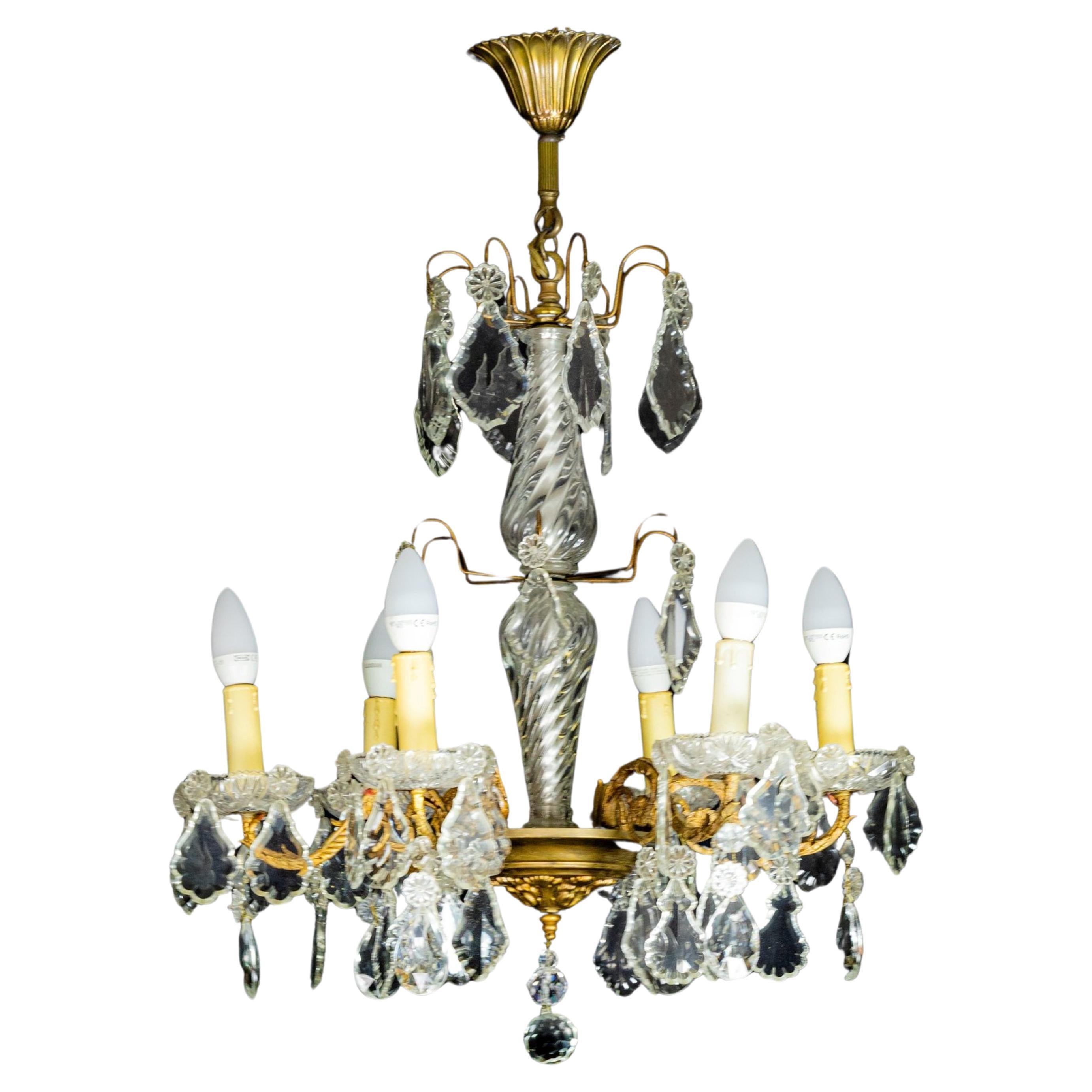 A Louis XV-Style bronze styled chandelier with crystal pendants and finials and tinted glass, completed and rewired with
candlestick holders and six light sockets. Rewired.

The chandelier is currently wired for both European Union and US standards