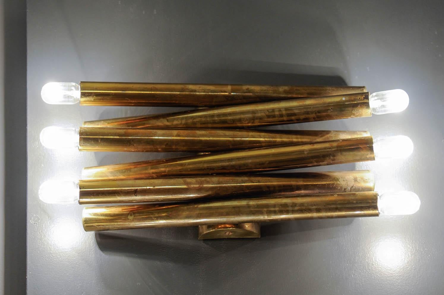 Nice wall sconce by Sciolari made of a rounded back plate and six brass tubes alternatively holding the lights.