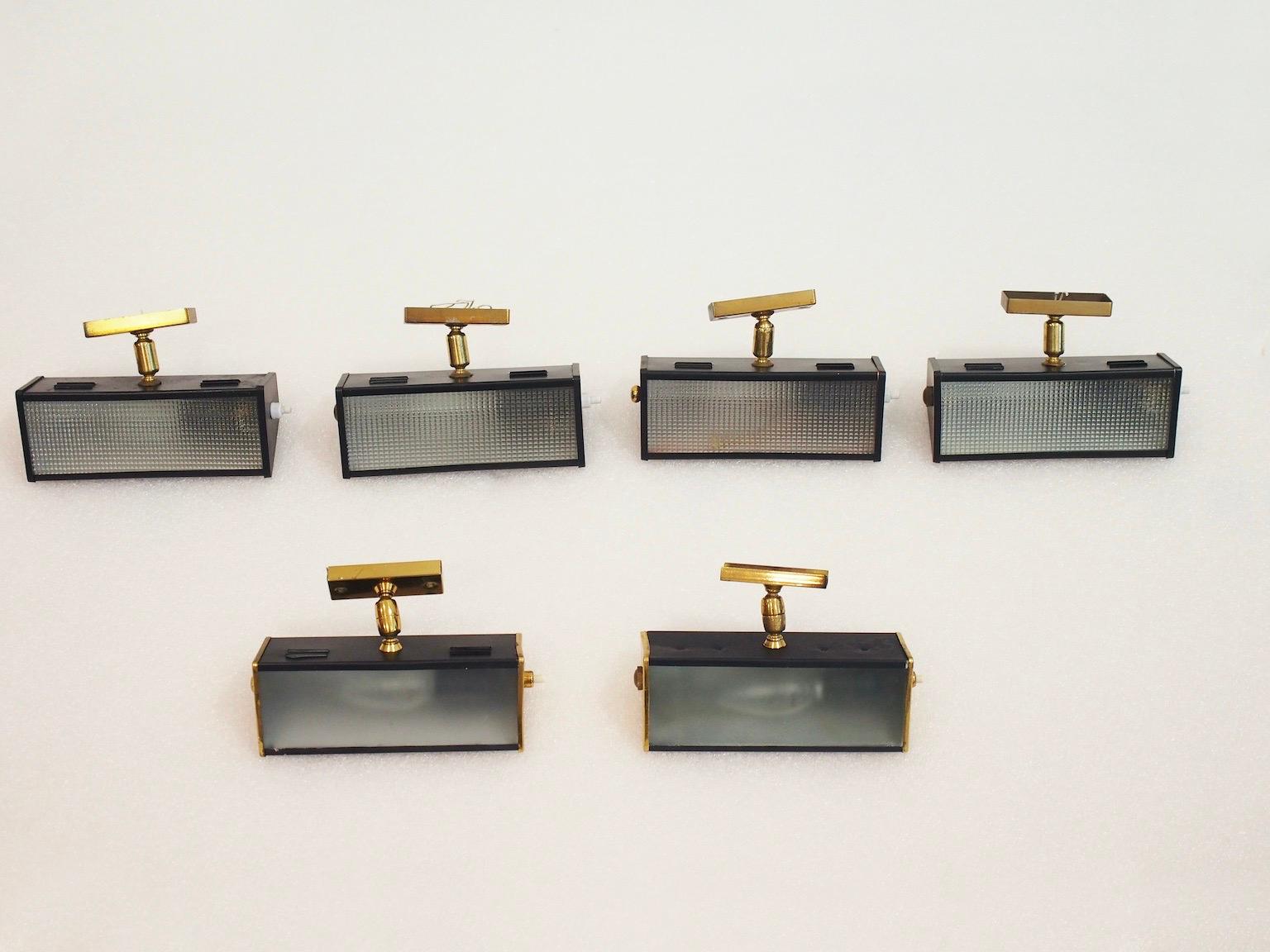 Seis apliques rectangulares de latón, metal pintado de negro y cristal. Interruptor en el lateral. Fabricado en Italia en los años cincuenta. Ten en cuenta que dos de las lámparas tienen una pantalla de cristal ligeramente diferente.