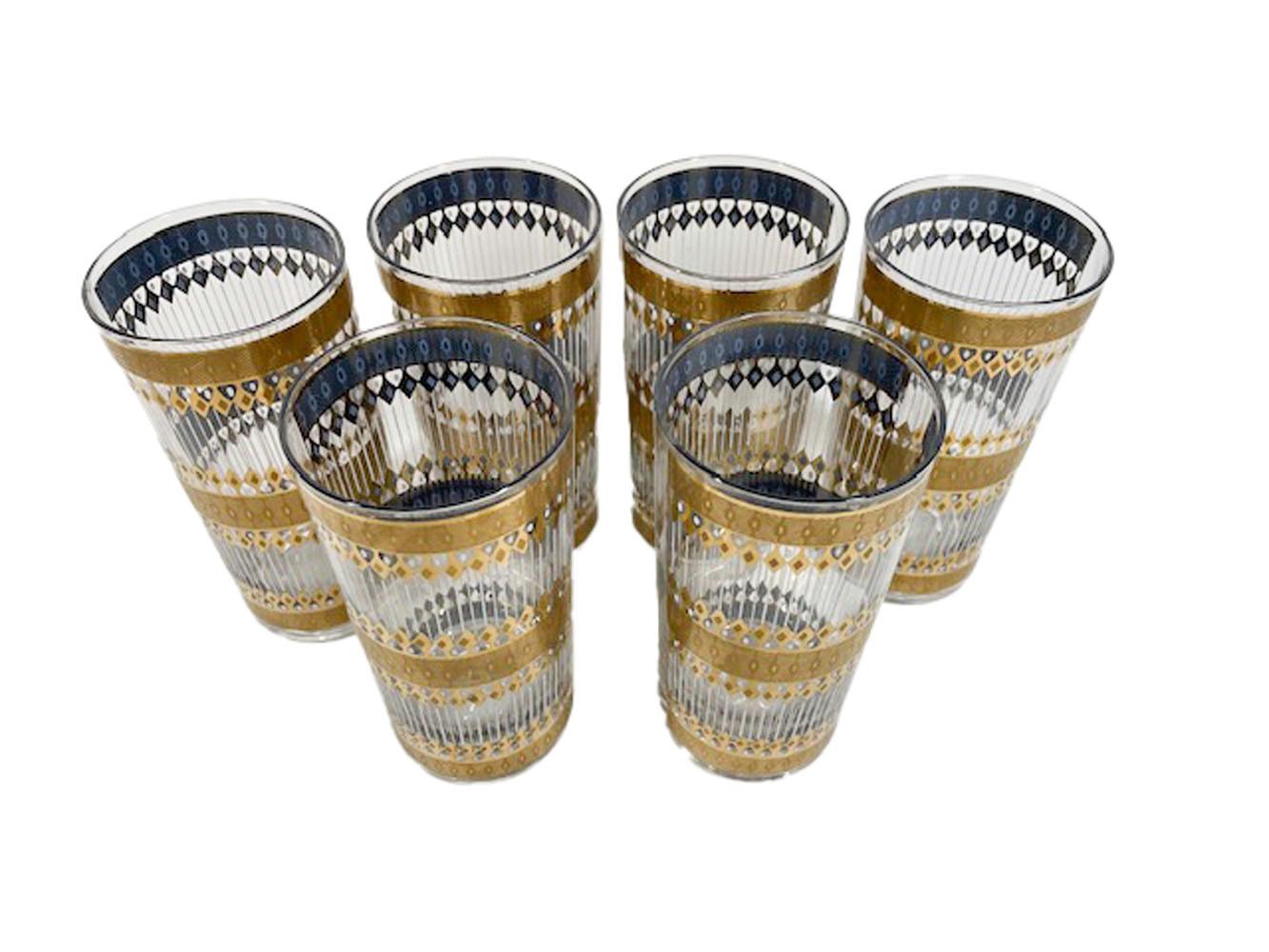 Six Mid-Century Modern highball glasses in the Barcelona pattern by Culver, LTD. 22 Karat gold with embossed geometric patterns over blue enamel, the blue with the same geometric patterns is visible only on the glass's interiors.