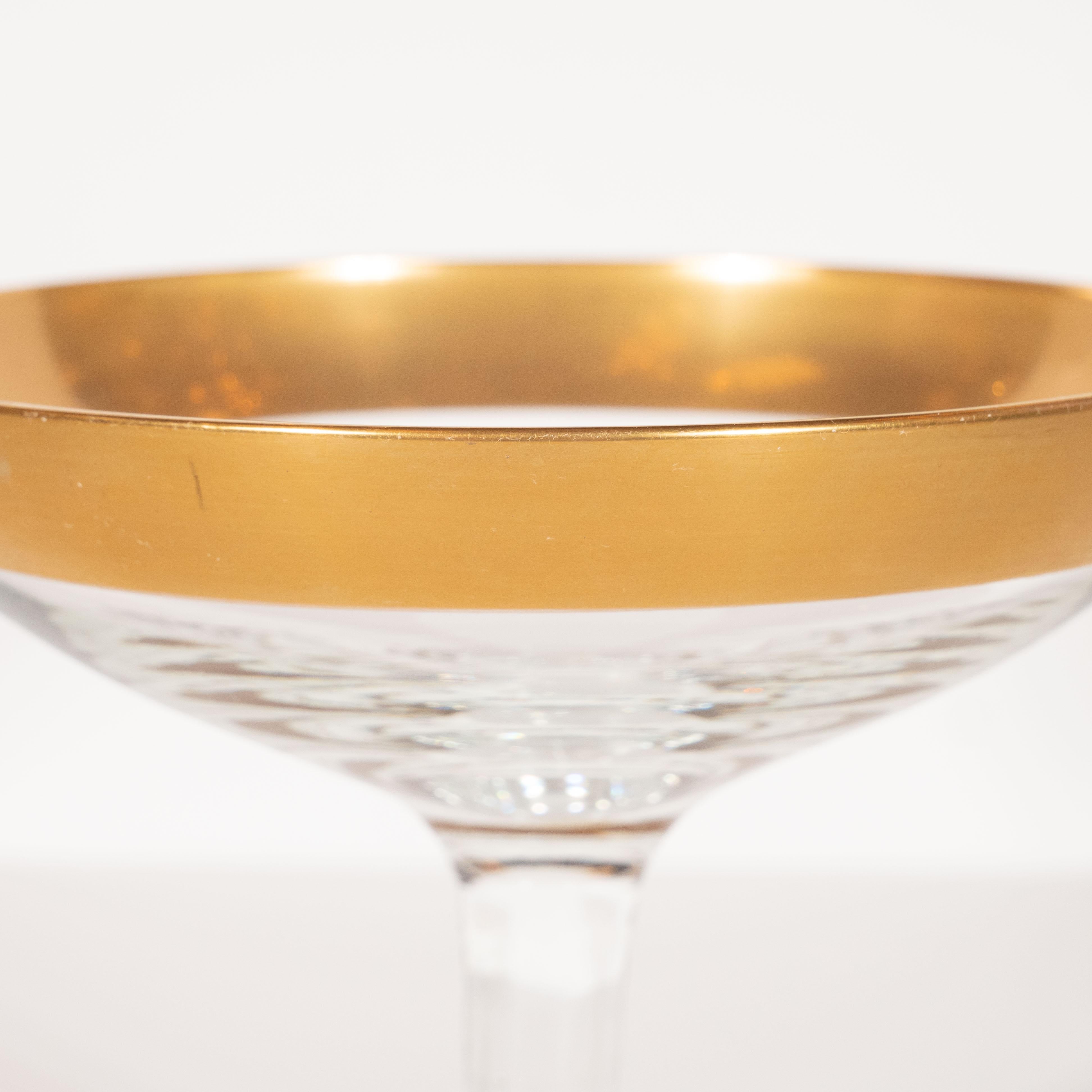 This elegant set of six champagne coupes were realized by the esteemed Mid-Century Modern designer, Dorothy Thorpe, circa 1945. They feature 24-karat gold rims- an exceptionally rare and sought after edition of this iconic glasses set-