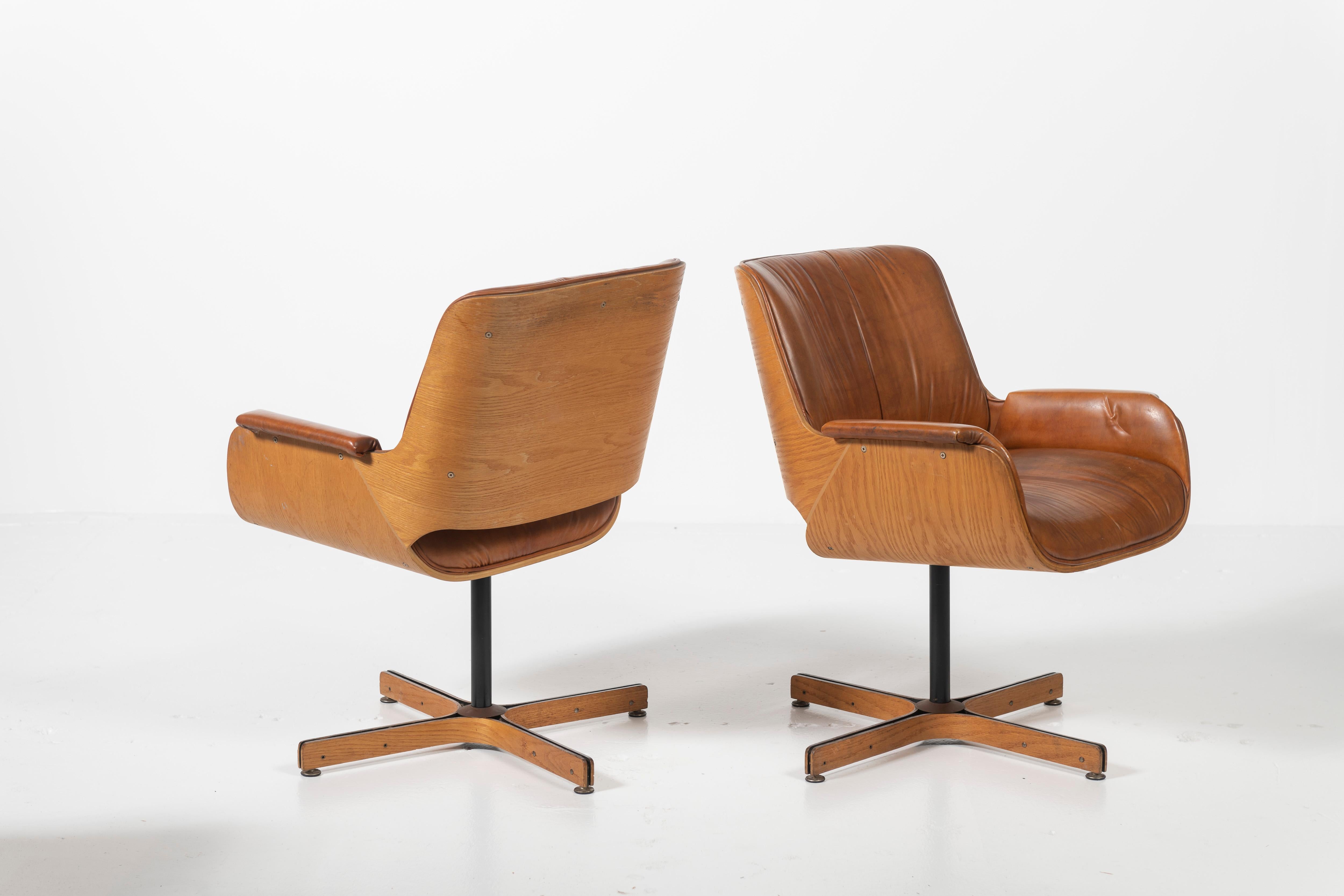 Metal Pair of Mid-Century Modern Swivel Faux Leather and Wood Armchairs by Plycraft