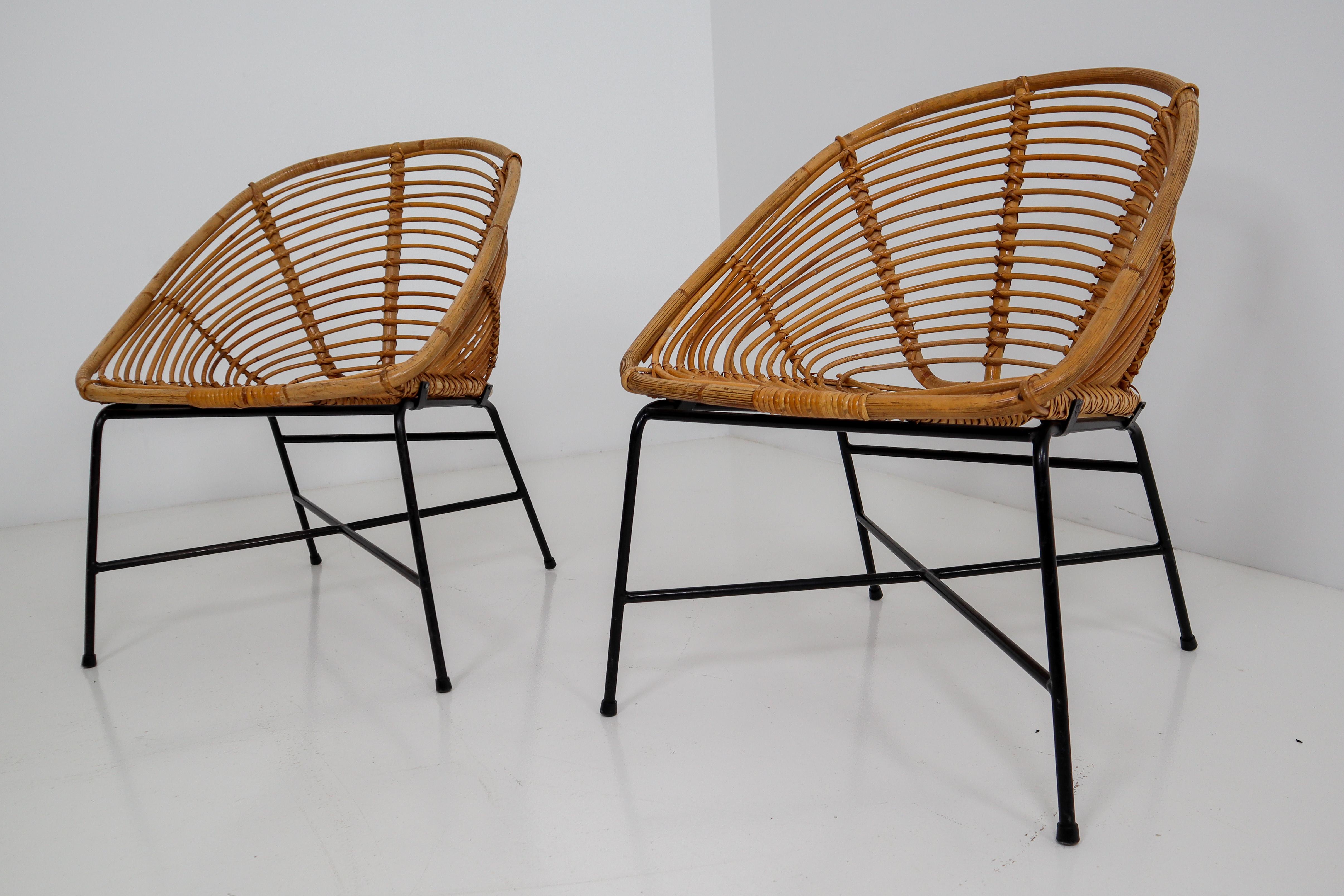 Elegant Italian rattan, wicker and iron chairs. Rattan in excellent condition. The frame is made of black lacquered steel. They are comfortable to sit in and create an inviting sitting experience. In very good vintage condition with light wear and