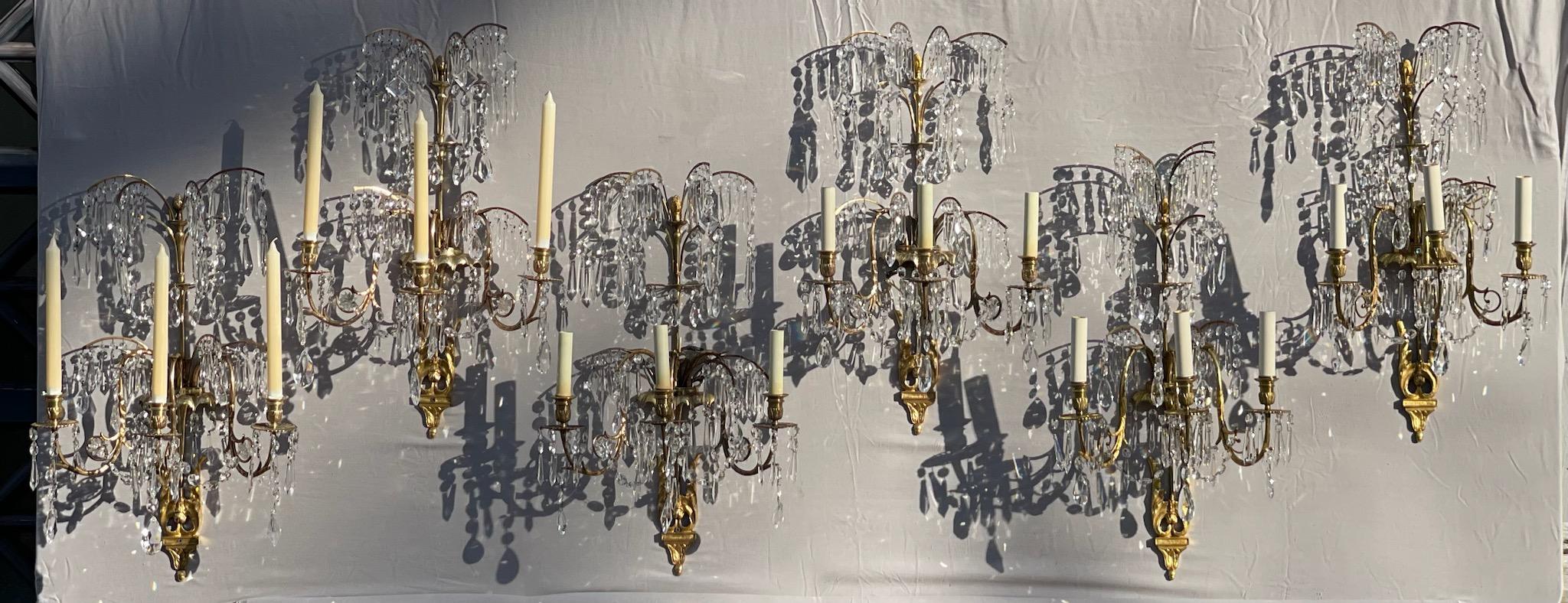 A rare find. Six Swedish Neo-Classical three arm gilt bronze and cut crystal wall sconces after German Designer and Architect Karl Friedrich Schinkel. Four have been French wired, two remain as candles. They came from a fine home in Manhattan.
