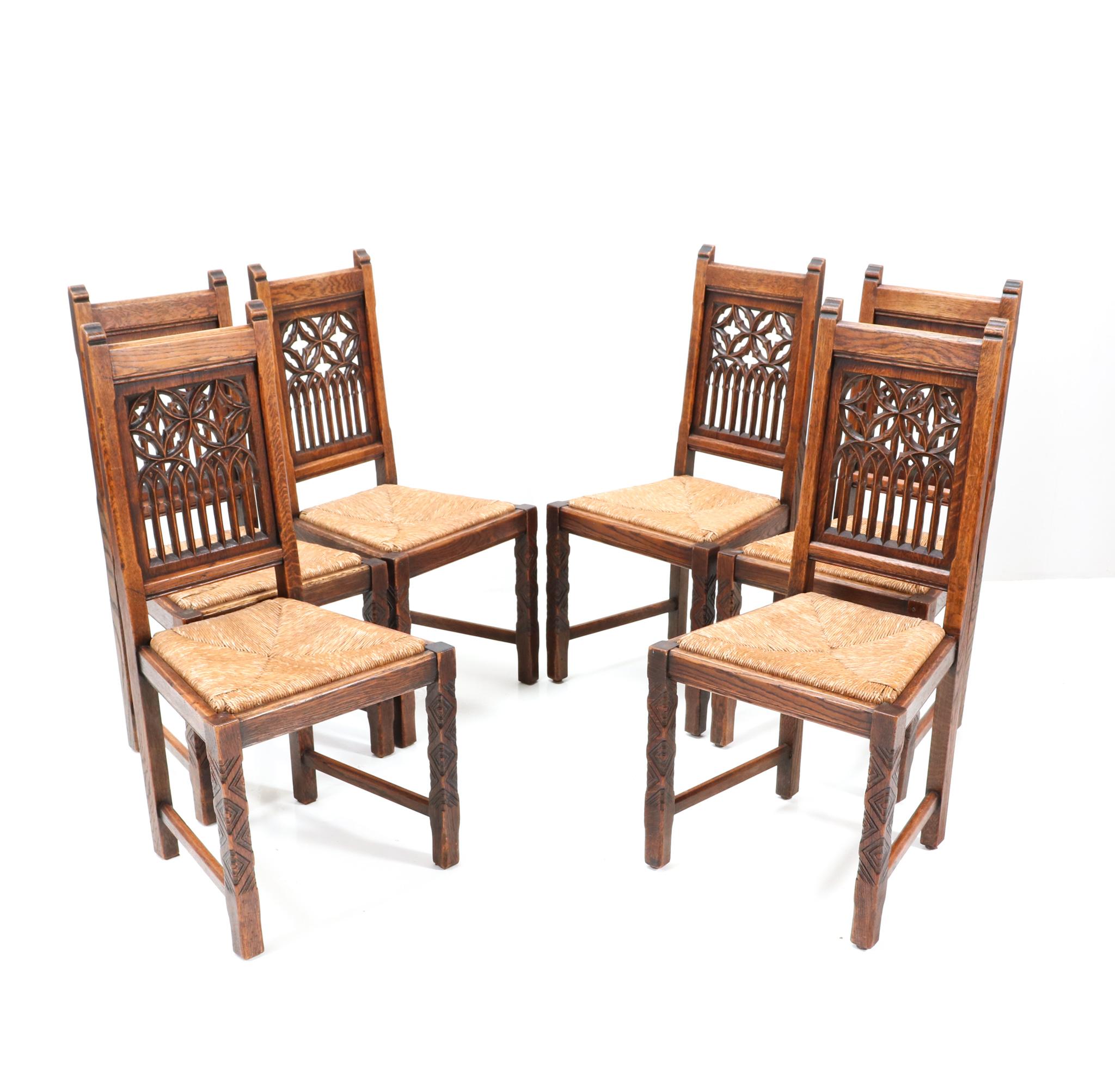 Magnificent and rare set of six Gothic Revival dining room chairs.
Striking Dutch design from the 1930s.
Solid oak frames with hand-carved church windows panels at the backside of the chairs.
The front legs have hand-carved decoration as